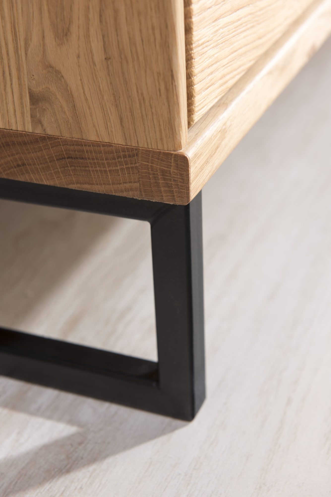 Solidna drewniana komoda z wyraźnym usłojeniem i metalowymi uchwytami