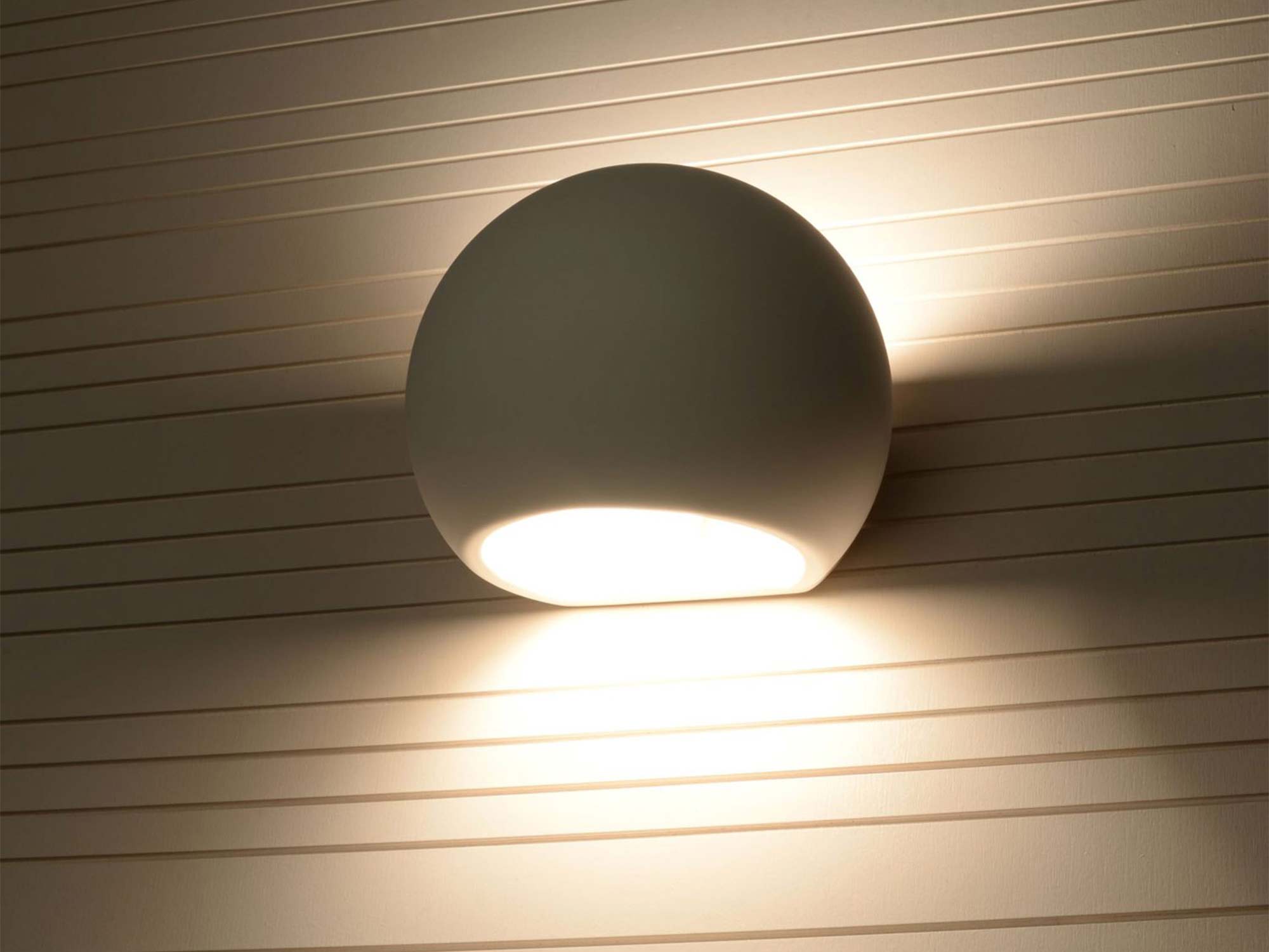 Ceramiczny kinkiet LED w kształcie półkuli na drewnianej ścianie Ceramiczny kinkiet LED w kształcie półkuli na drewnianej ścianie