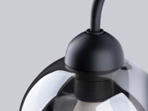 Miniaturka 3 - Zbliżenie na konstrukcję lampy – klosz szklany i czarna oprawa