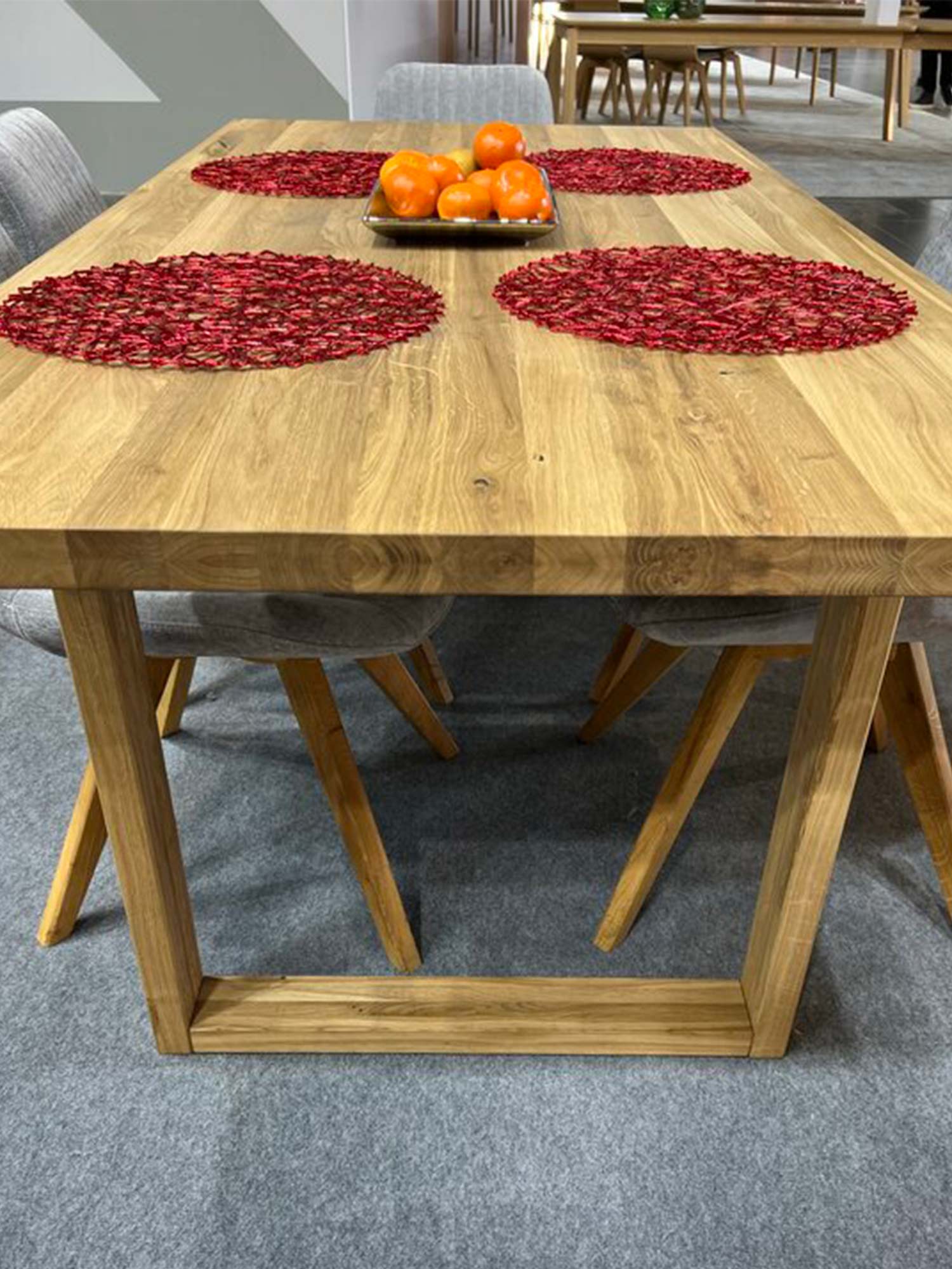 Drewniany stół z czerwonymi podkładkami i owocami