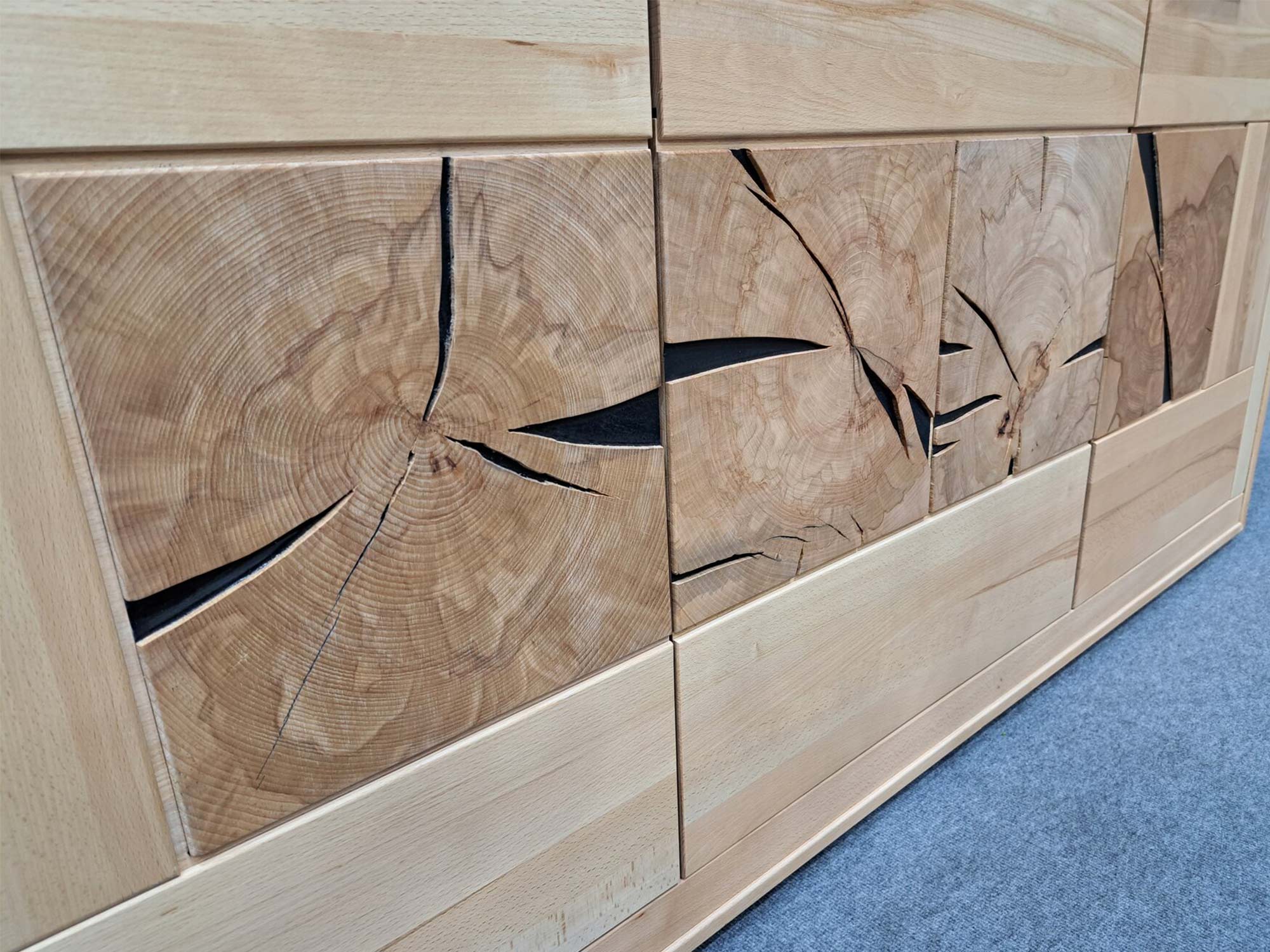 Detal drewnianych frontów szafki z czarnym geometrycznym wzorem