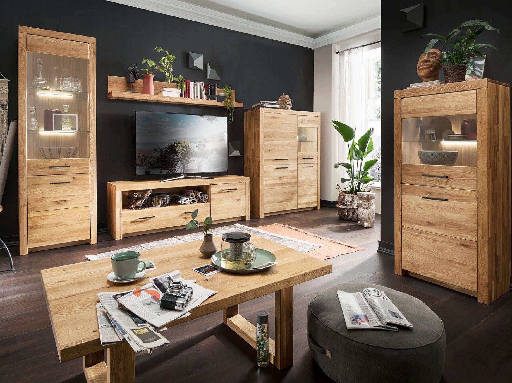 Aranżacja salonu z drewnianym zestawem mebli i przeszkloną witryną