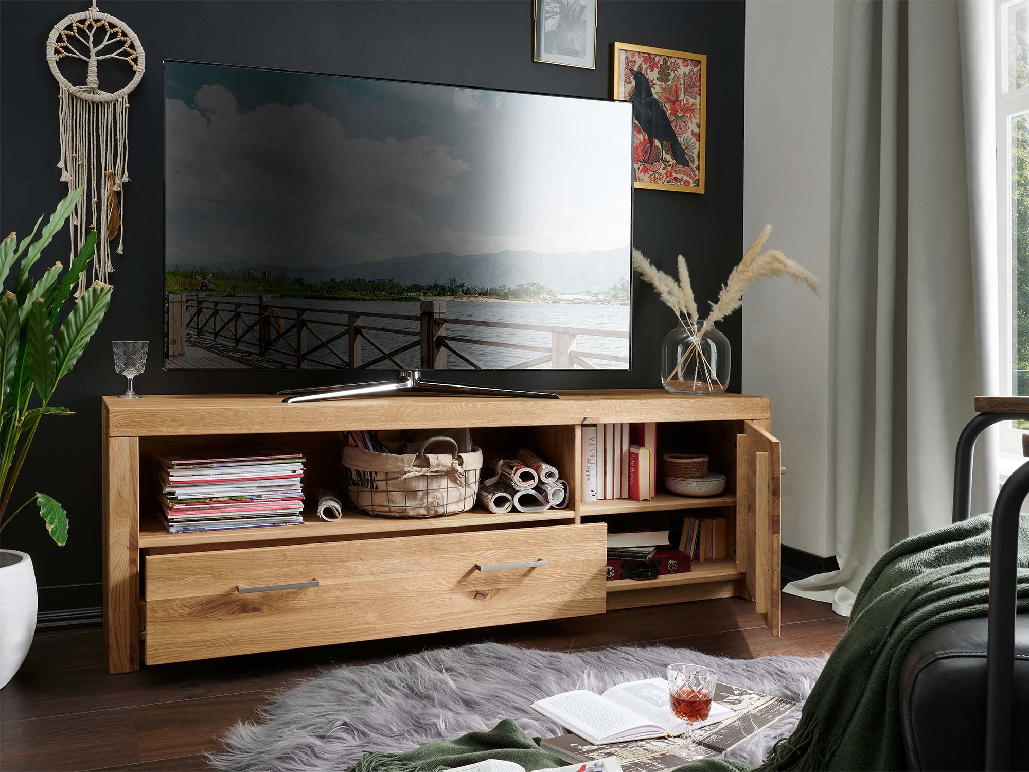 Ciemna aranżacja salonu z meblami RTV i zielonym fotelem