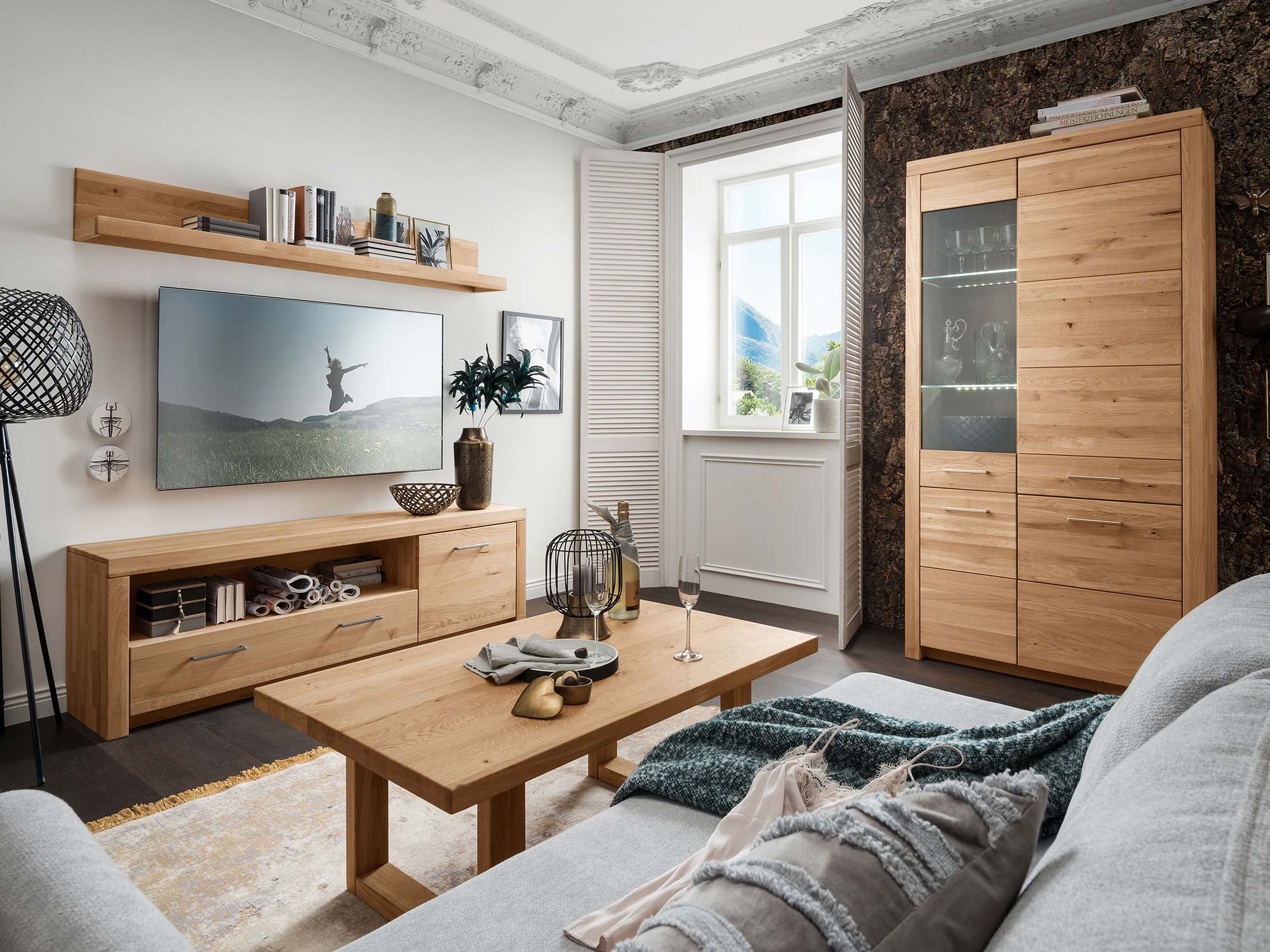 Szafka RTV w salonie z szarą sofą i drewnianą podłogą