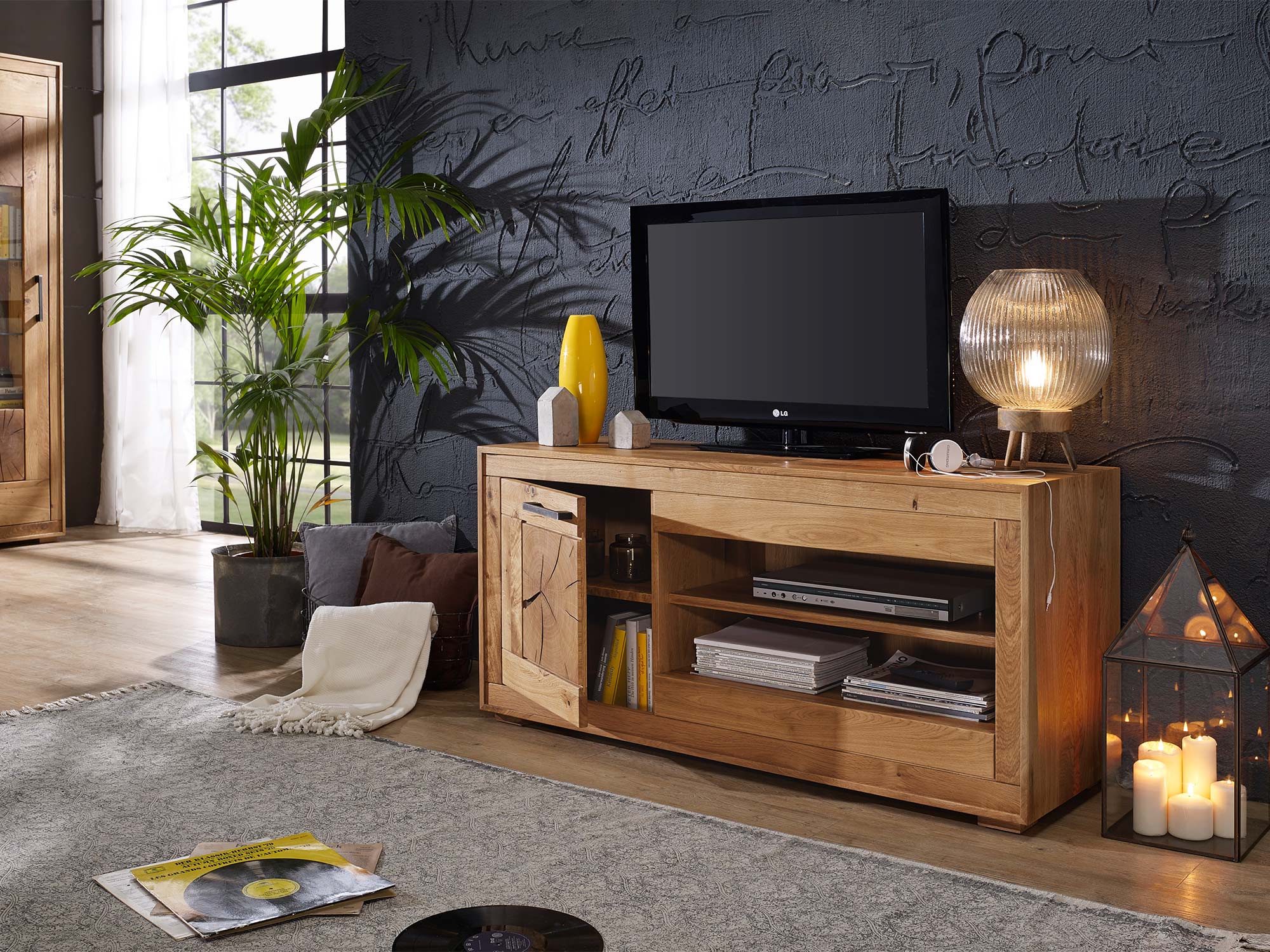 Komoda RTV z rzeźbionymi frontami i czarną ścianą w tle