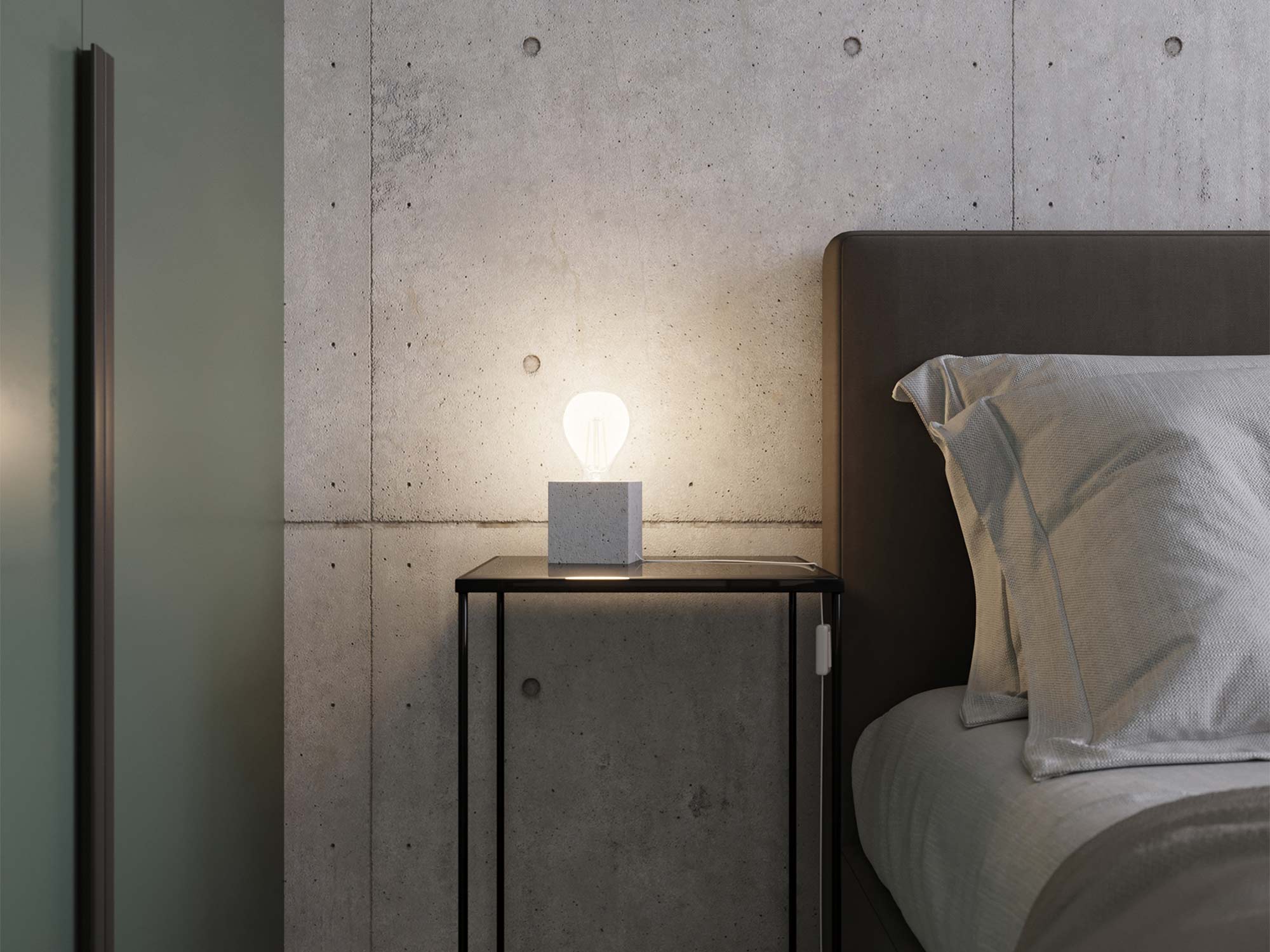 Sypialnia loftowa z lampką nocną na betonowej szafce
