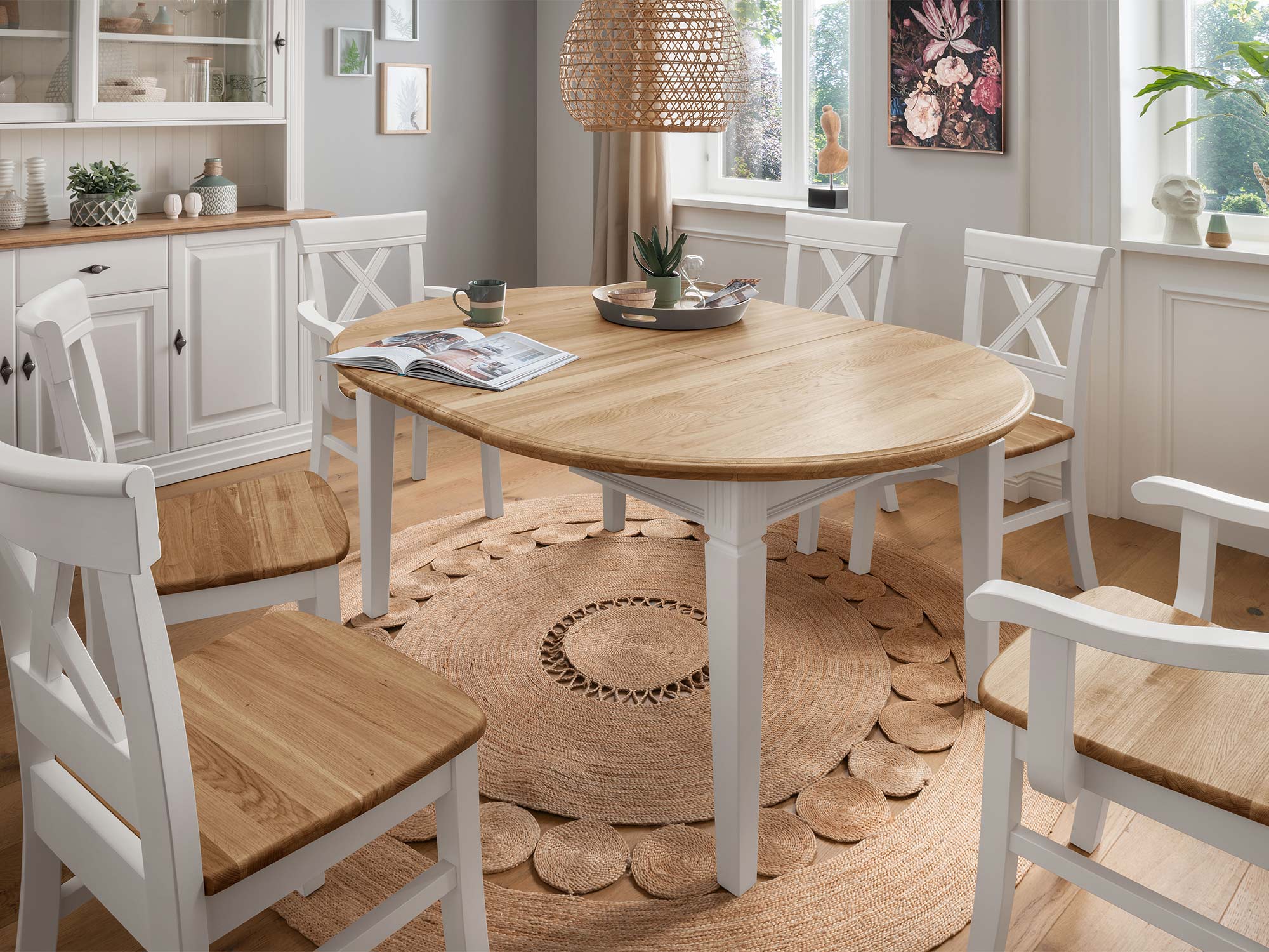 Okrągły stół i białe krzesła w rustykalnej aranżacji kuchni