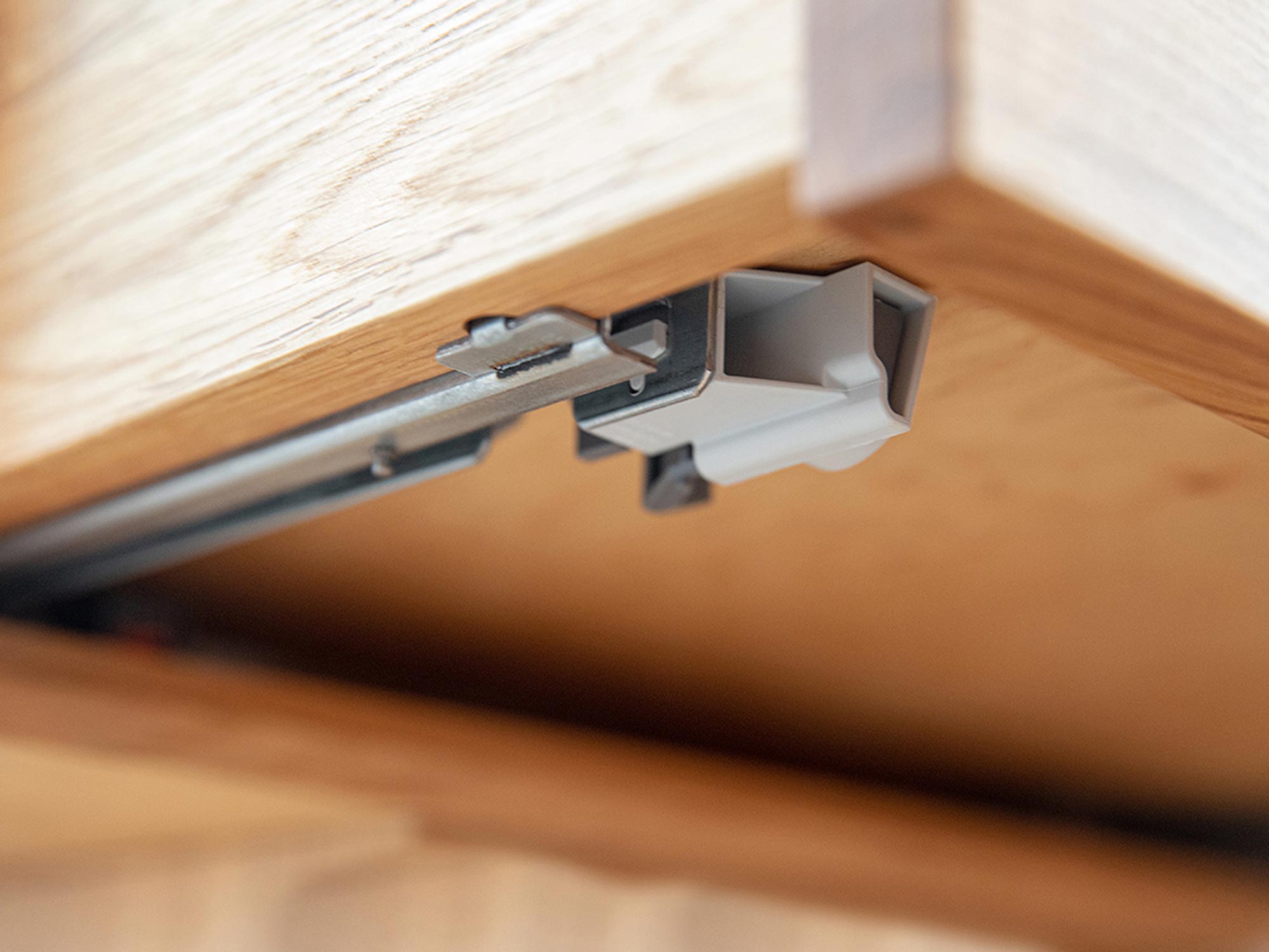Metalowy zawias w szafce nocnej z wnętrzem z naturalnego drewna