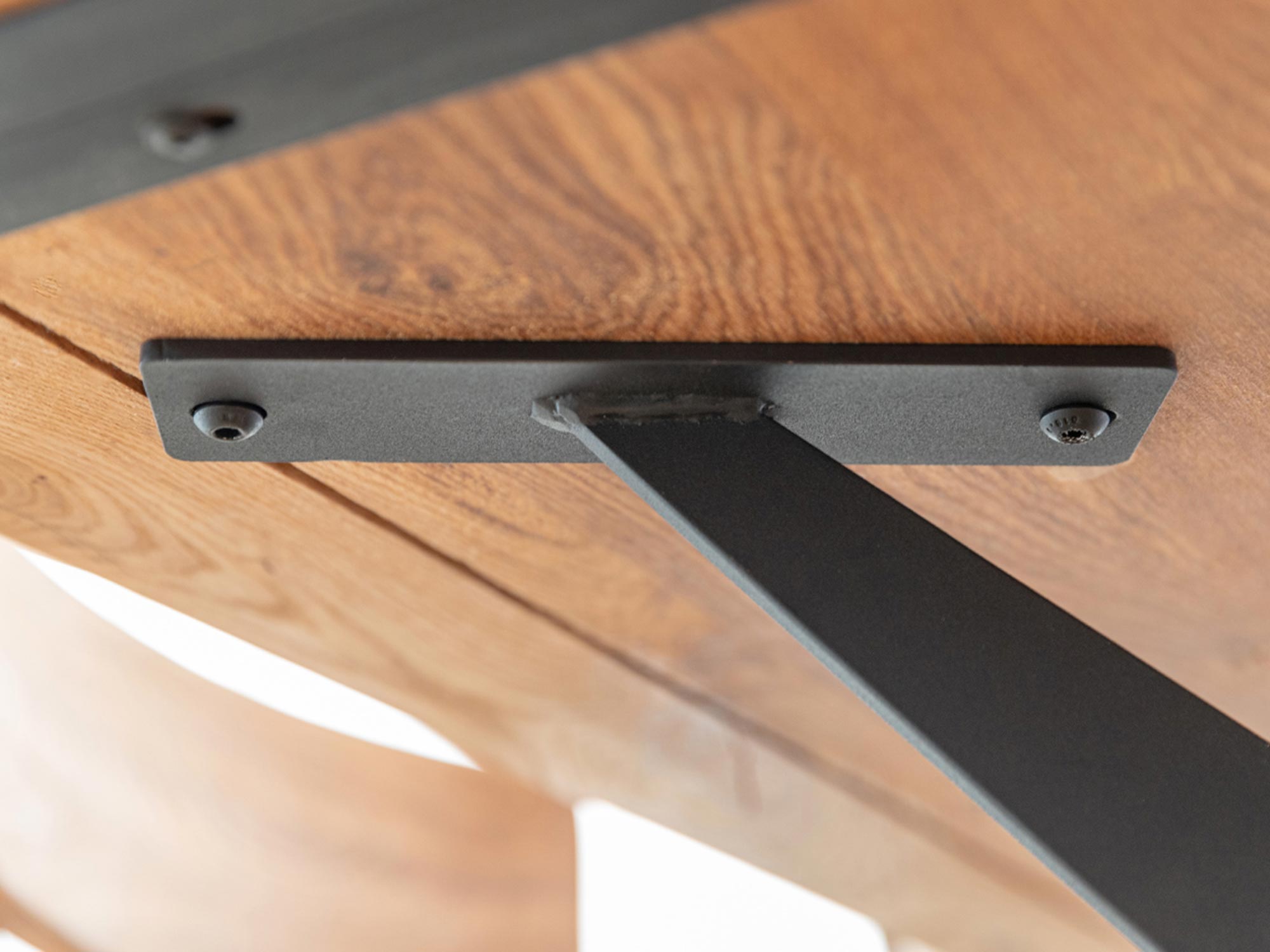 Zbliżenie mocowania pod blatem stołu z litego dębu