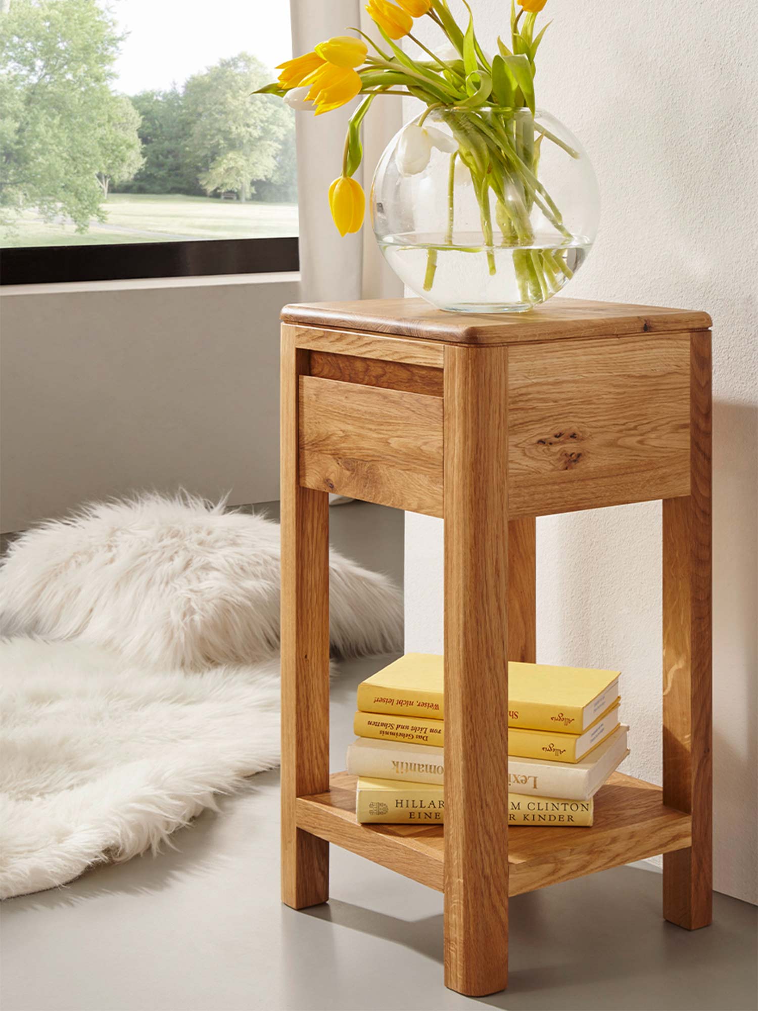 Drewniany stolik pomocniczy z dolną półką i szufladą przy oknie