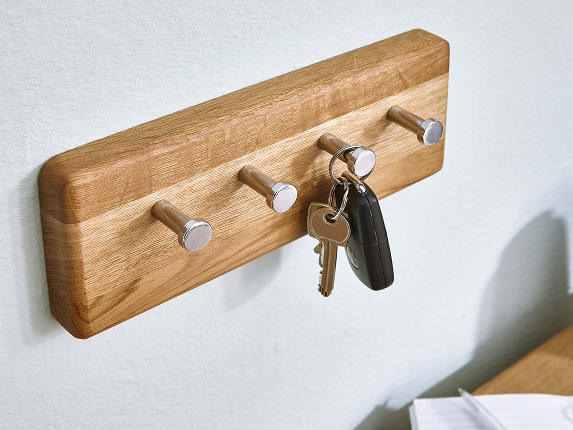 Wieszak z kluczami zamocowany na drewnianej desce