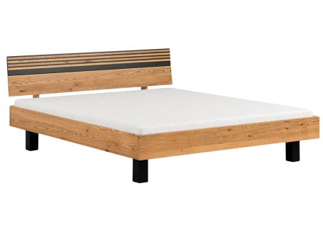 Minimalistyczne łóżko z dębu z czarnymi nogami i niskim zagłówkiem
