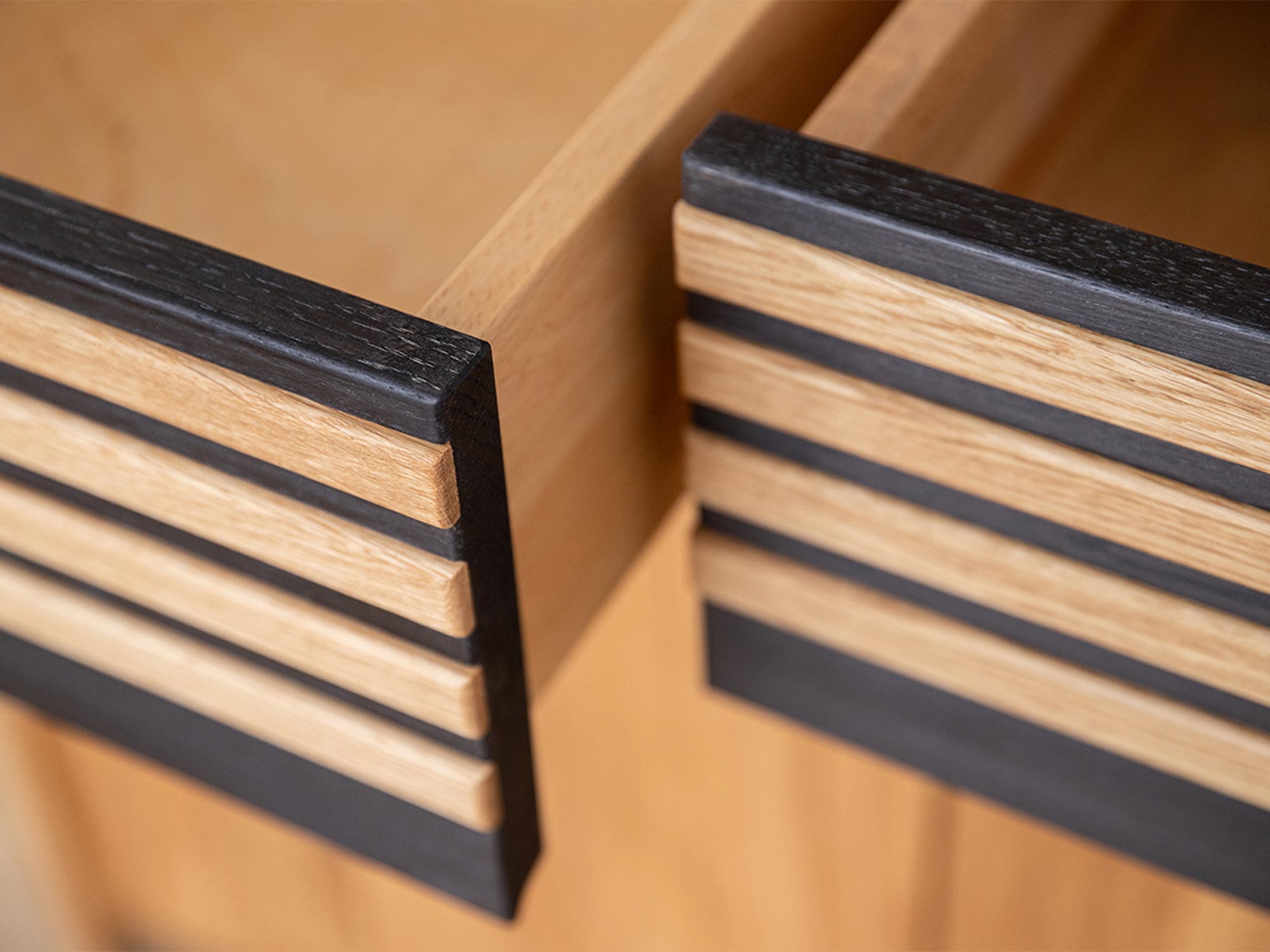 Detal wysuwanej szuflady z czarnym uchwytem z drewna
