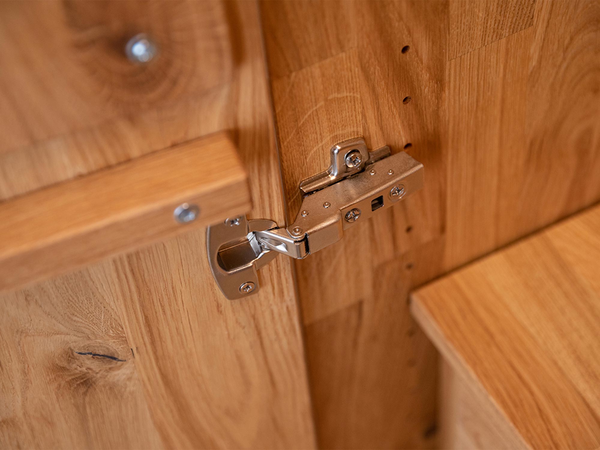 Detal zawiasu w szafie dębowej z wewnętrzną półką