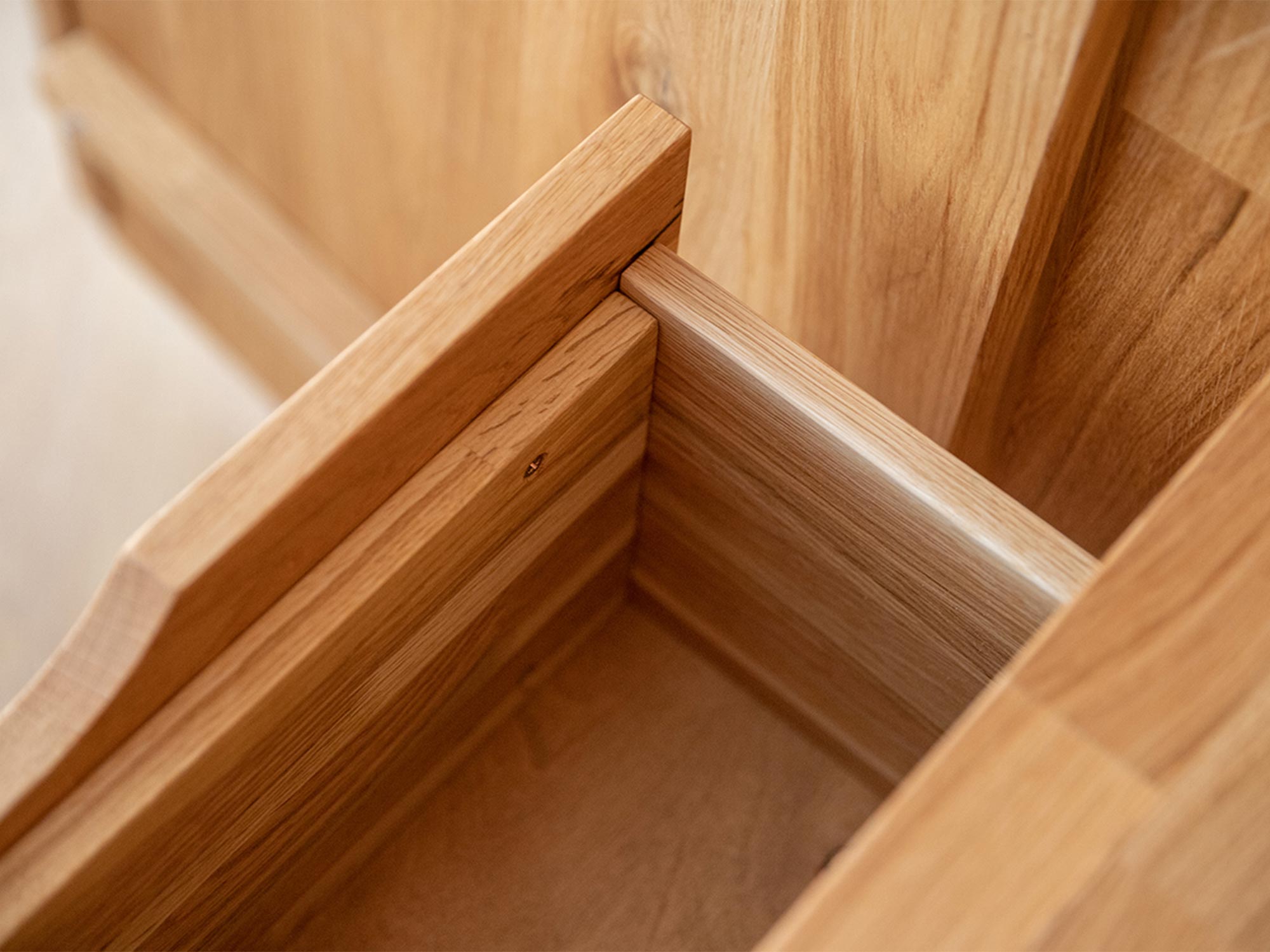 Zbliżenie na prowadnicę drewnianej szuflady bez metalowych elementów