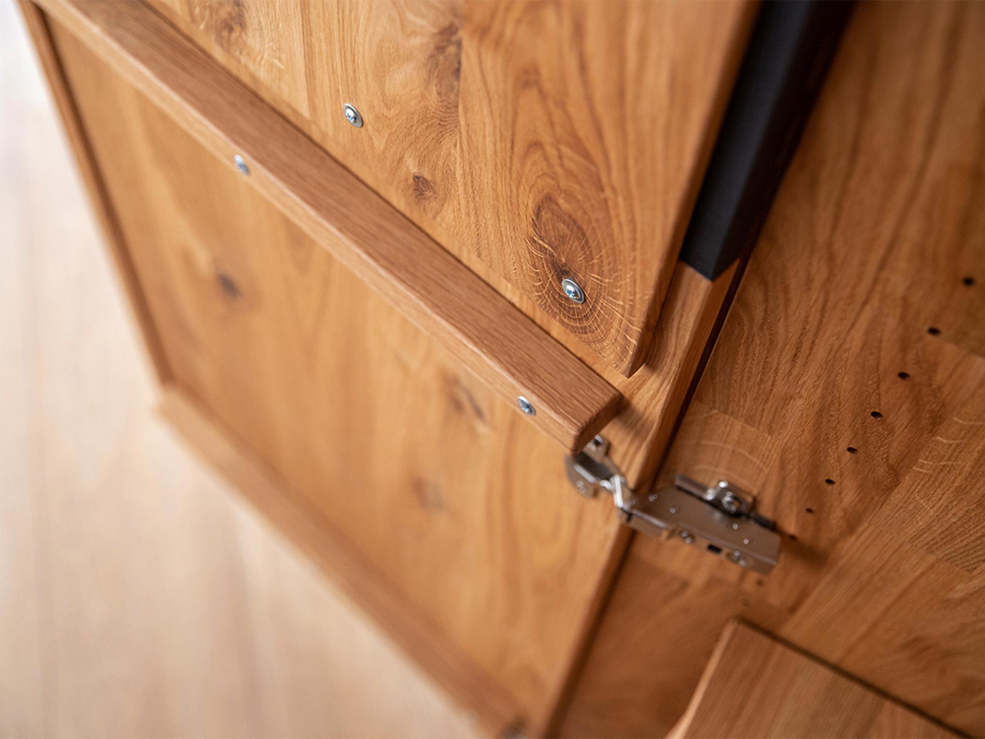 Zbliżenie na metalowy zawias w meblach dębowych