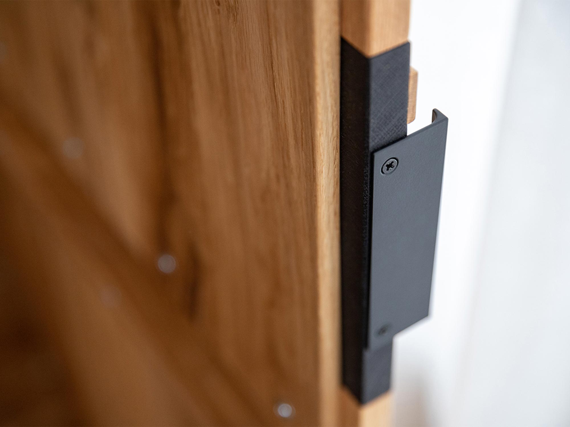 Detal mocowania uchwytu czarnego w meblu z dębu