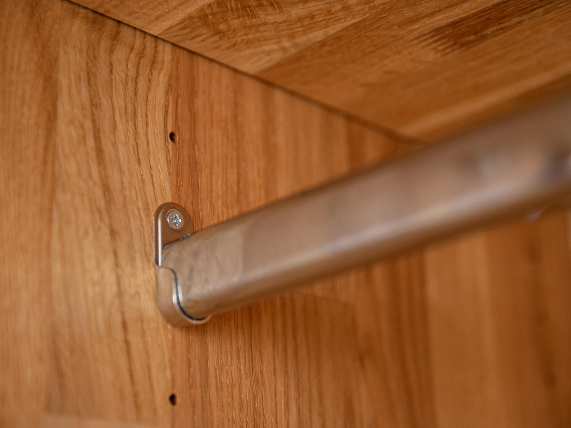 Detal drążka na ubrania w drewnianej szafie z wieszakiem