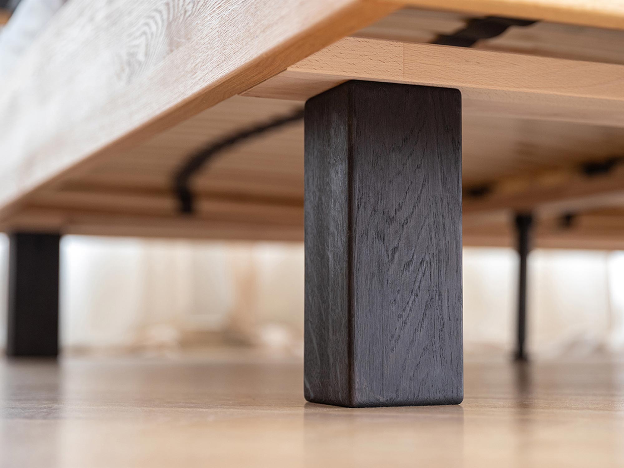 Czarna noga łóżka z naturalnego drewna w stylu loftowym