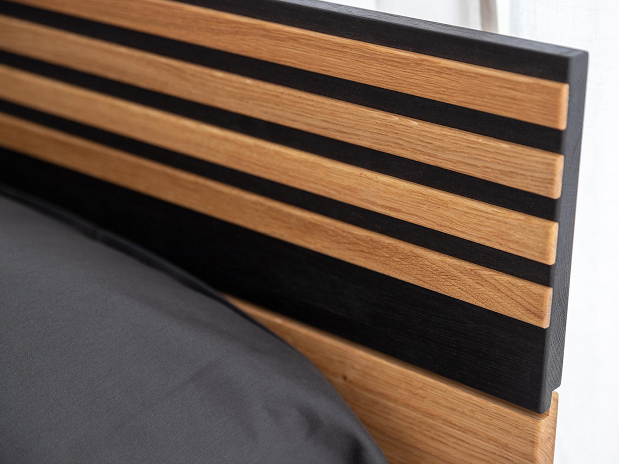 Zagłówek łóżka dębowego z czarnymi listwami ozdobnymi