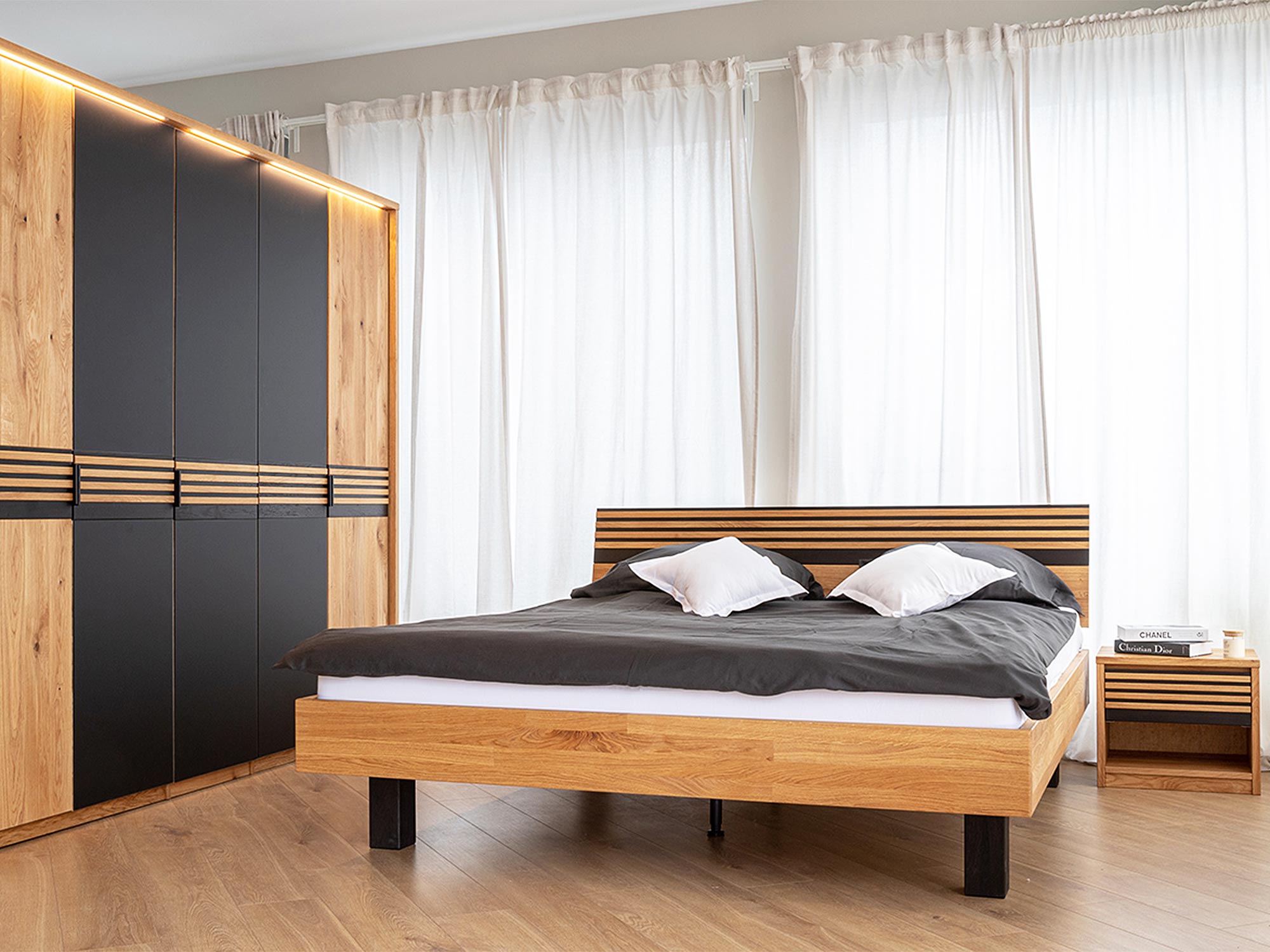 Drewniane łóżko dębowe z czarnymi nogami i ozdobnym zagłówkiem