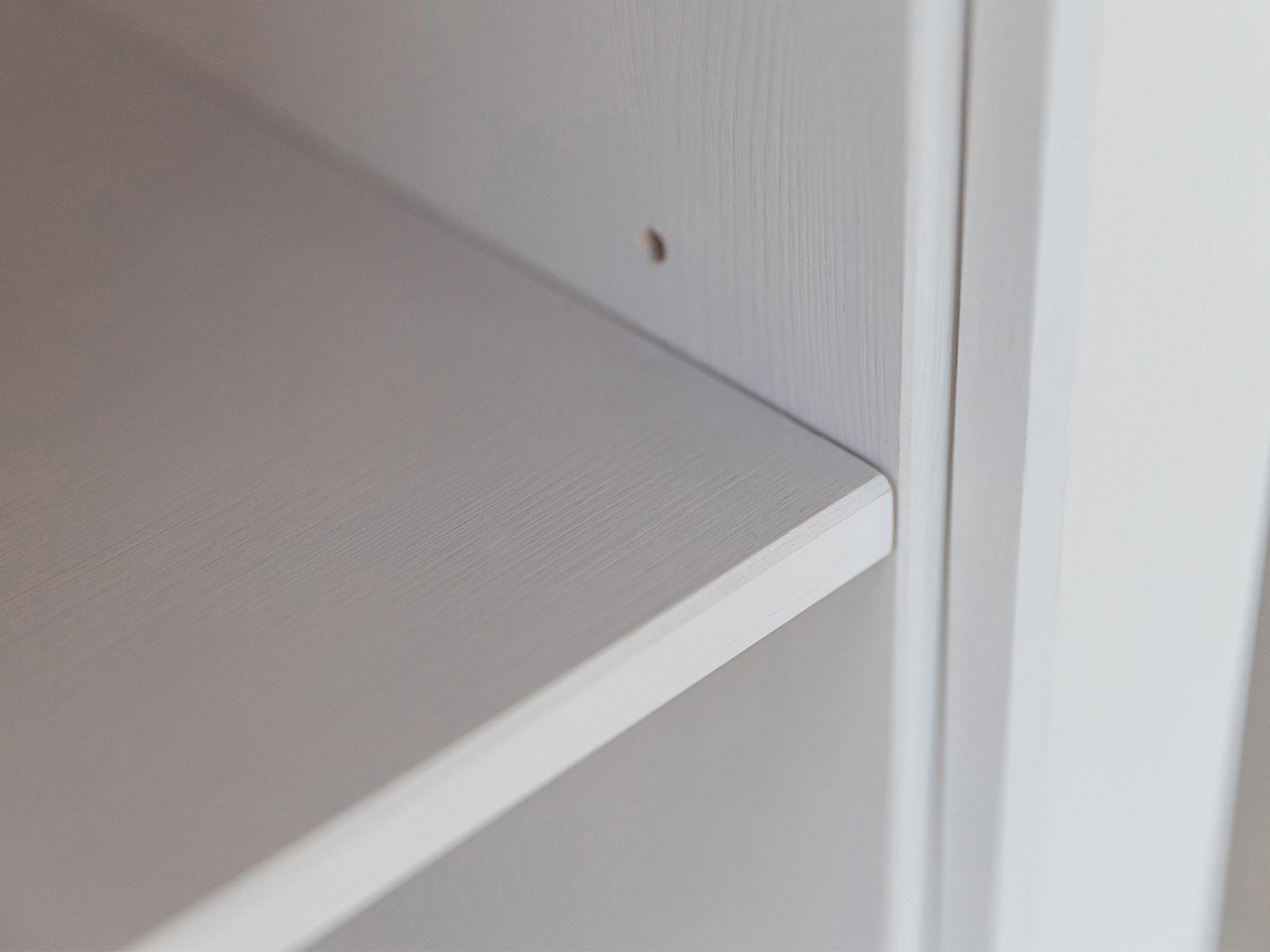 Półka wewnętrzna w białej witrynie z rowkami