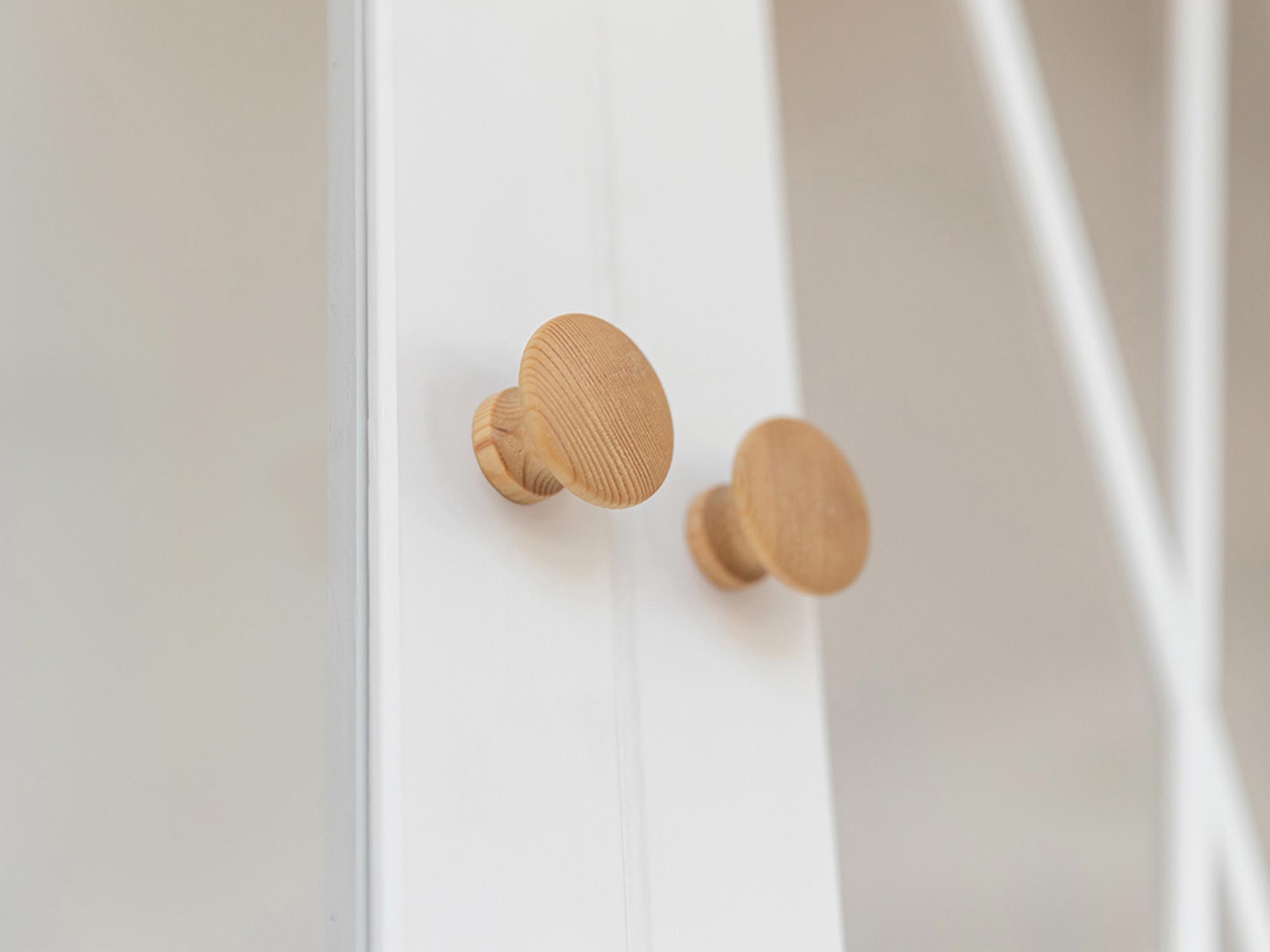 Drewniane uchwyty w klasycznym kształcie na tle frontu