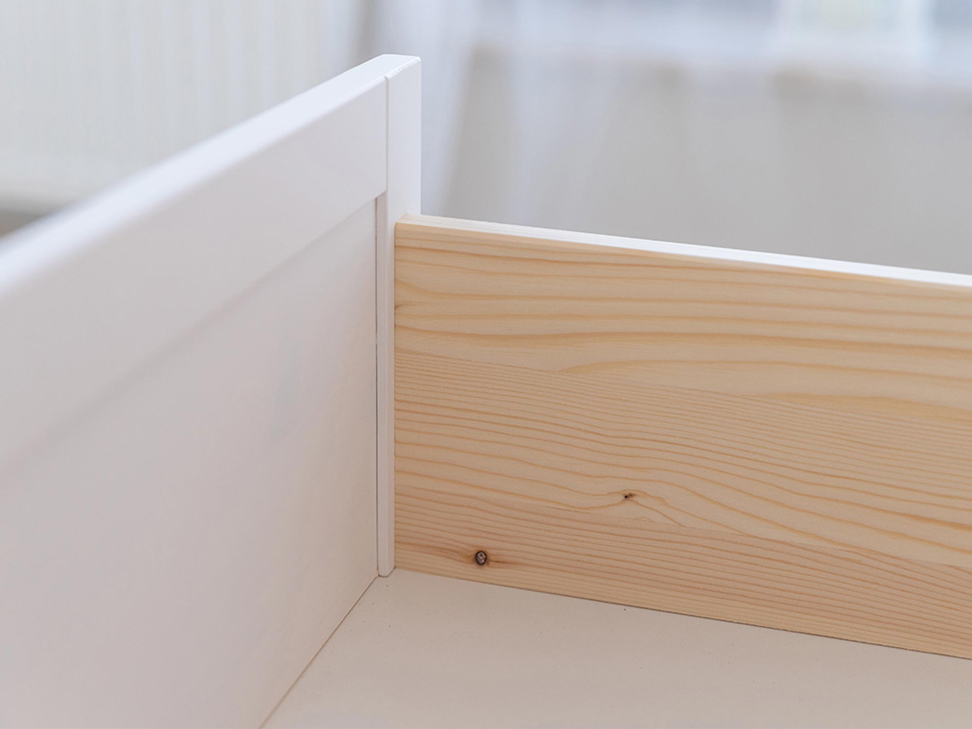 Zbliżenie łączenia płyty MDF i płyty sosnowej w szufladzie