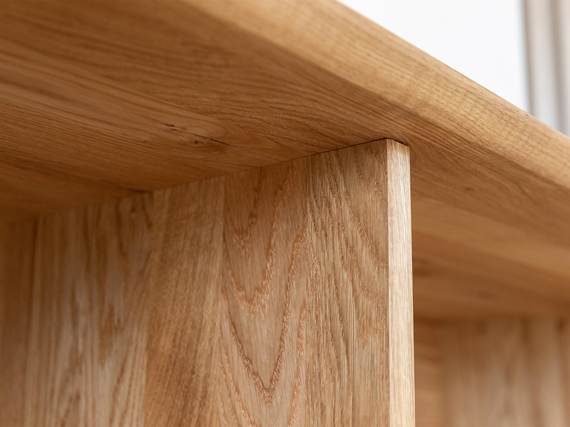 Detal połączenia półki i frontu w meblu z czarnym szkłem