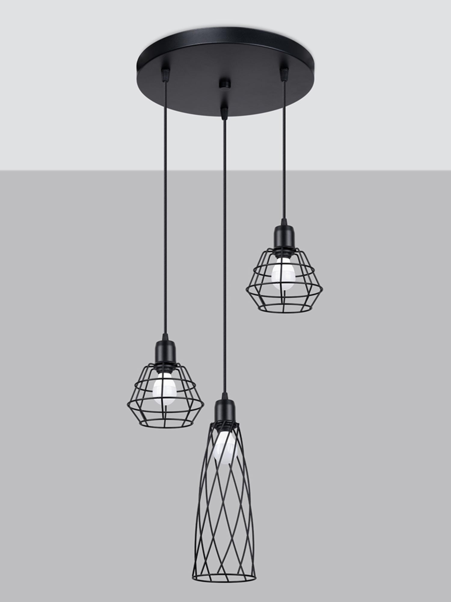 Trzy druciane lampy wiszące z czarnymi oprawami na szarym tle Trzy druciane lampy wiszące z czarnymi oprawami na szarym tle