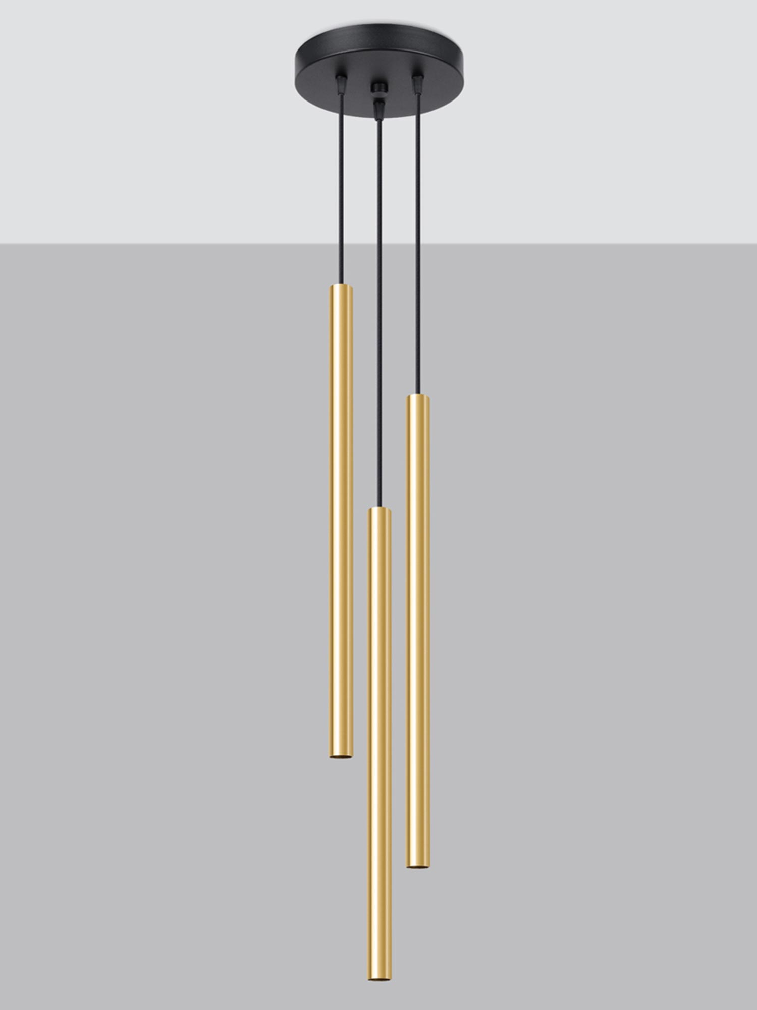 Lampa wisząca tubowa w złotym kolorze na tle szarej ściany Lampa wisząca tubowa w złotym kolorze na tle szarej ściany