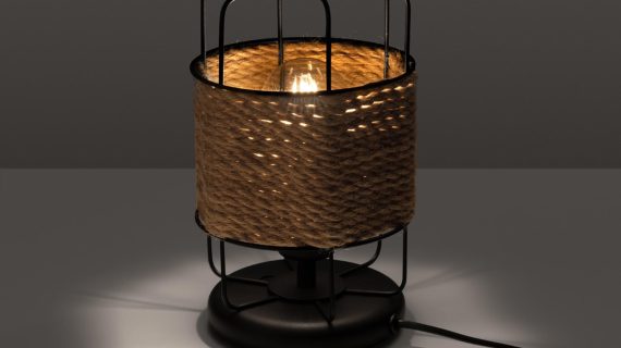 Miniaturka 2 - Wiklinowa lampa stołowa z włączonym światłem w ciemnym wnętrzu