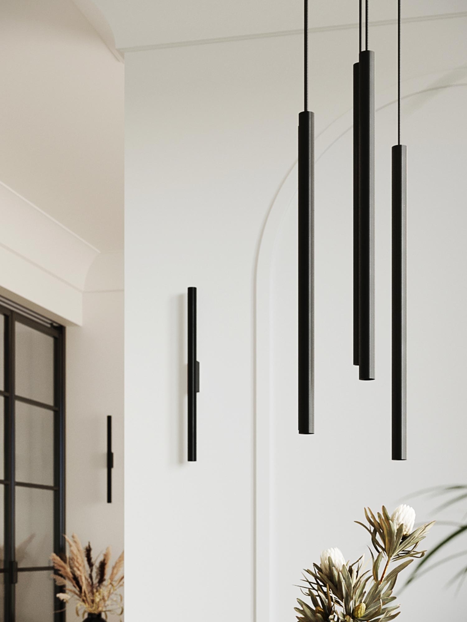 Trzy czarne lampy tubowe na białej ścianie w holu wejściowym Trzy czarne lampy tubowe na białej ścianie w holu wejściowym