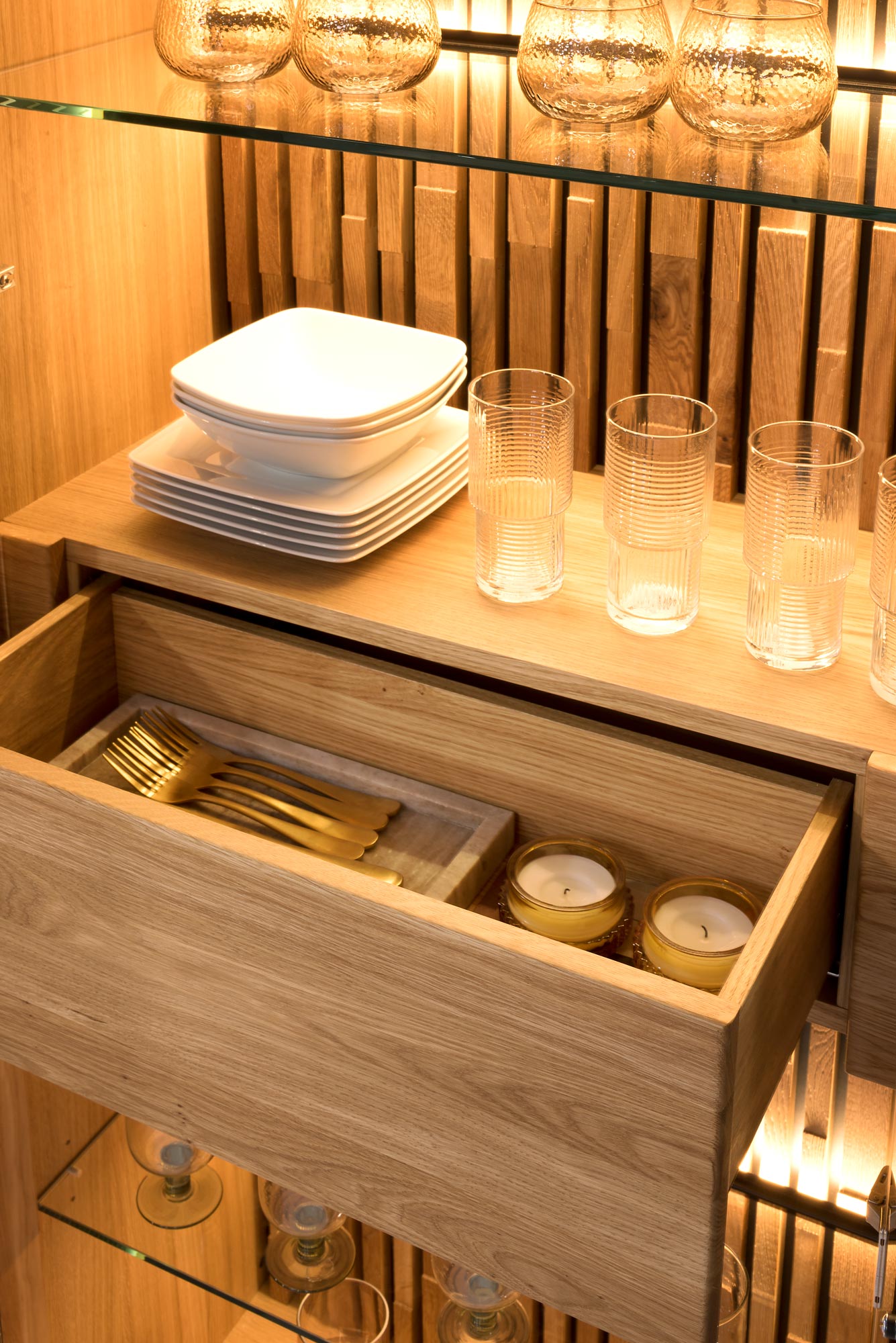 Zbliżenie na ekspozycję w witrynie dębowej z szklanymi półkami i podświetleniem