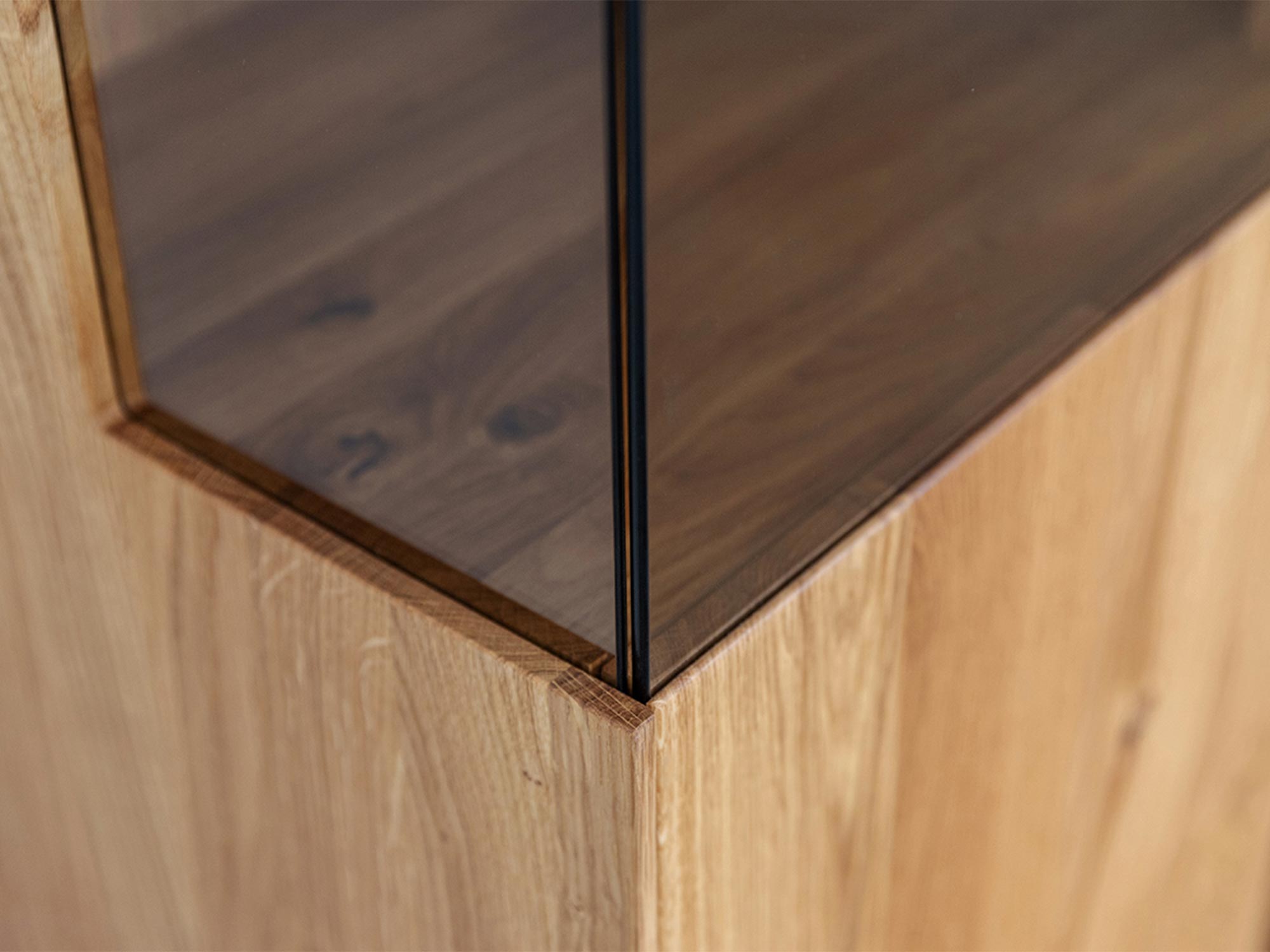 Zbliżenie na element szklany w witrynie dębowej