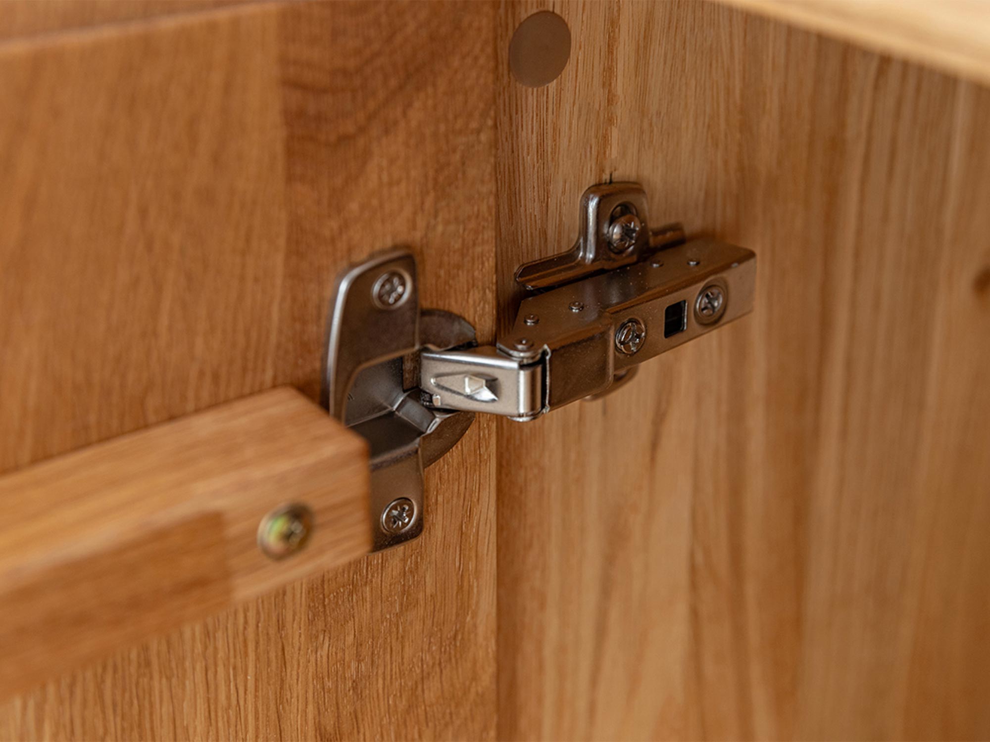 Zbliżenie na zawias drzwi szafki z litego dębu