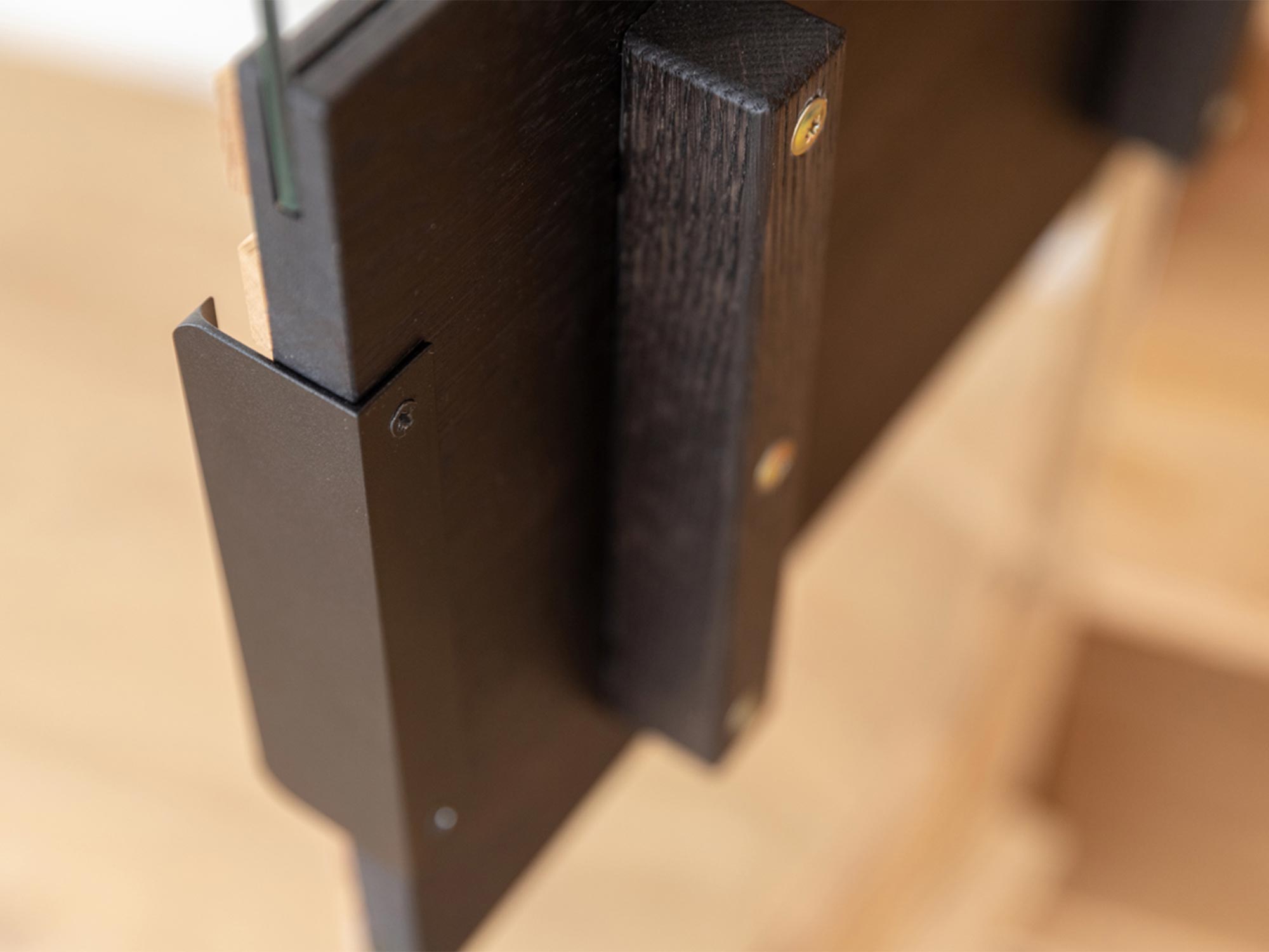 Detal wykończenia drewnianej witryny z czarnymi uchwytami