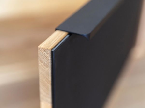 Detail černého úchytu v moderní komodzie dubové