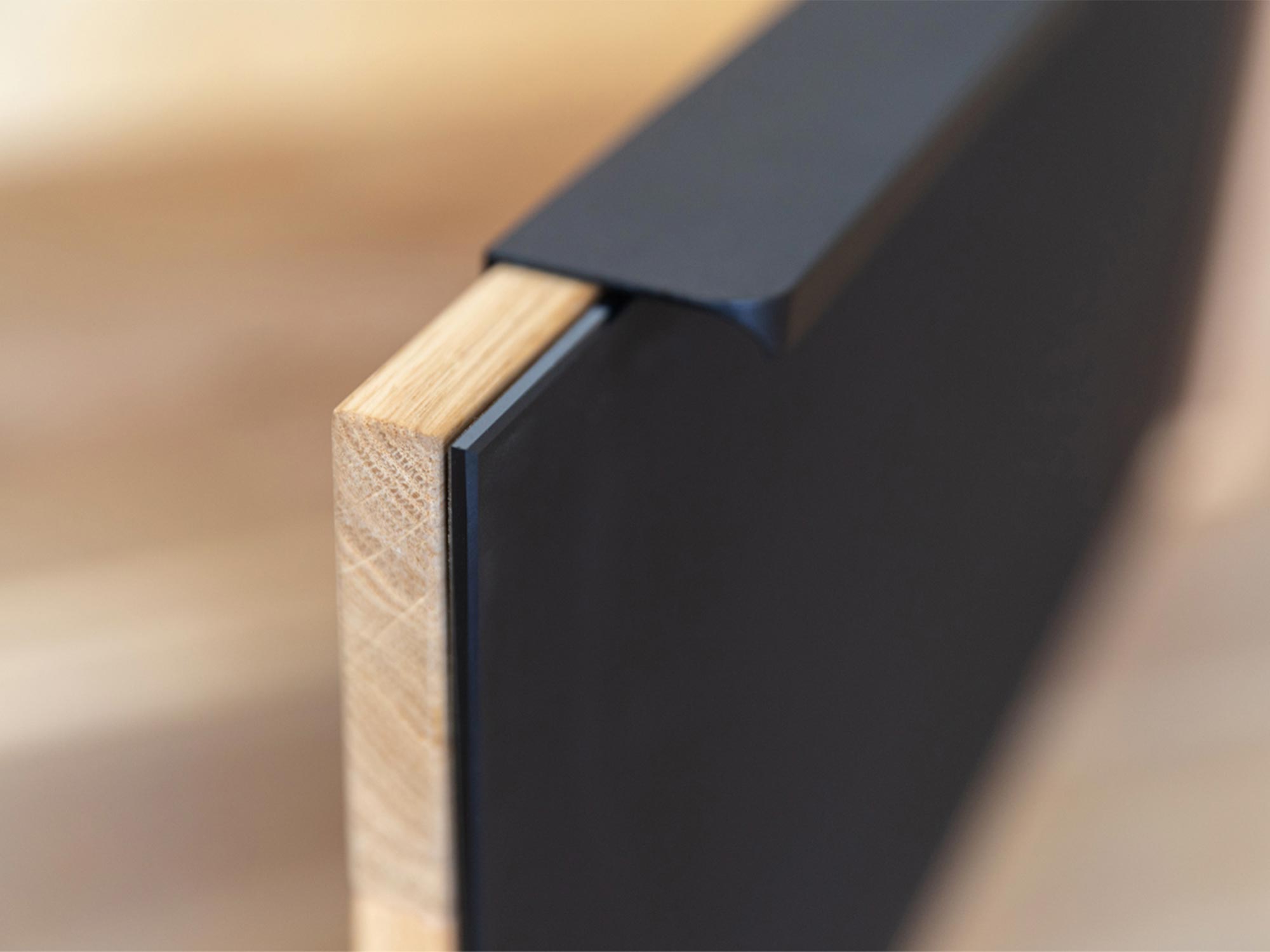 Detal czarnego uchwytu w nowoczesnej komodzie dębowej