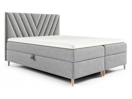 Łóżko tapicerowane w jasnoszarym kolorze z geometrycznym pikowaniem