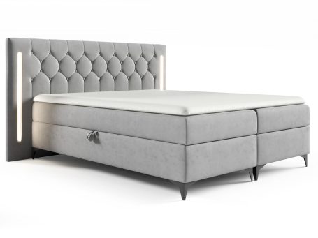 Łóżko tapicerowane w jasnoszarym kolorze z prostym, eleganckim wykończeniem