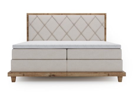 Beżowe łóżko tapicerowane z dużą powierzchnią spania