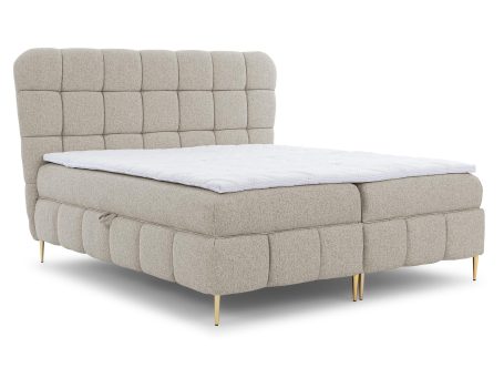 Beżowe łóżko tapicerowane z pikowanym zagłówkiem i złotymi nogami – eleganckie łóżko z miękkim wykończeniem, idealne do klasycznych wnętrz.