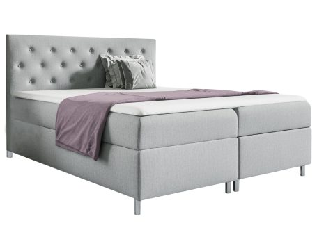 Łóżko tapicerowane w szarym kolorze z pikowanym zagłówkiem