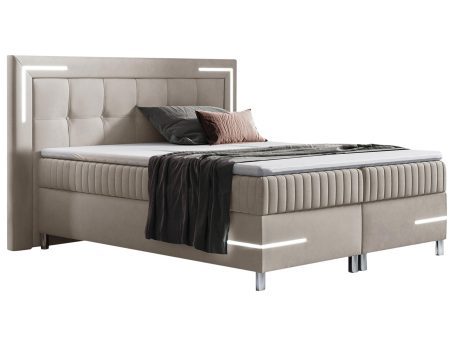 Nowoczesne łóżko tapicerowane w beżowym kolorze z metalowymi nóżkami