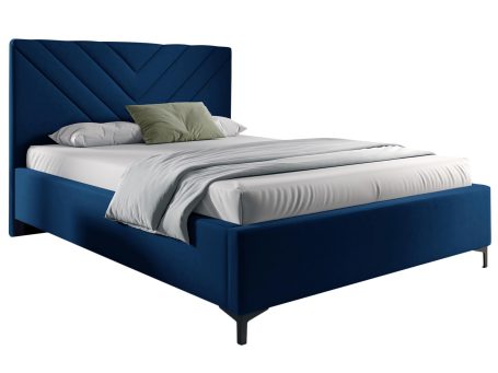 Łóżko tapicerowane w kolorze granatowym z ozdobnym zagłówkiem – nowoczesne łóżko do sypialni, które dodaje wnętrzu wyrazistości.