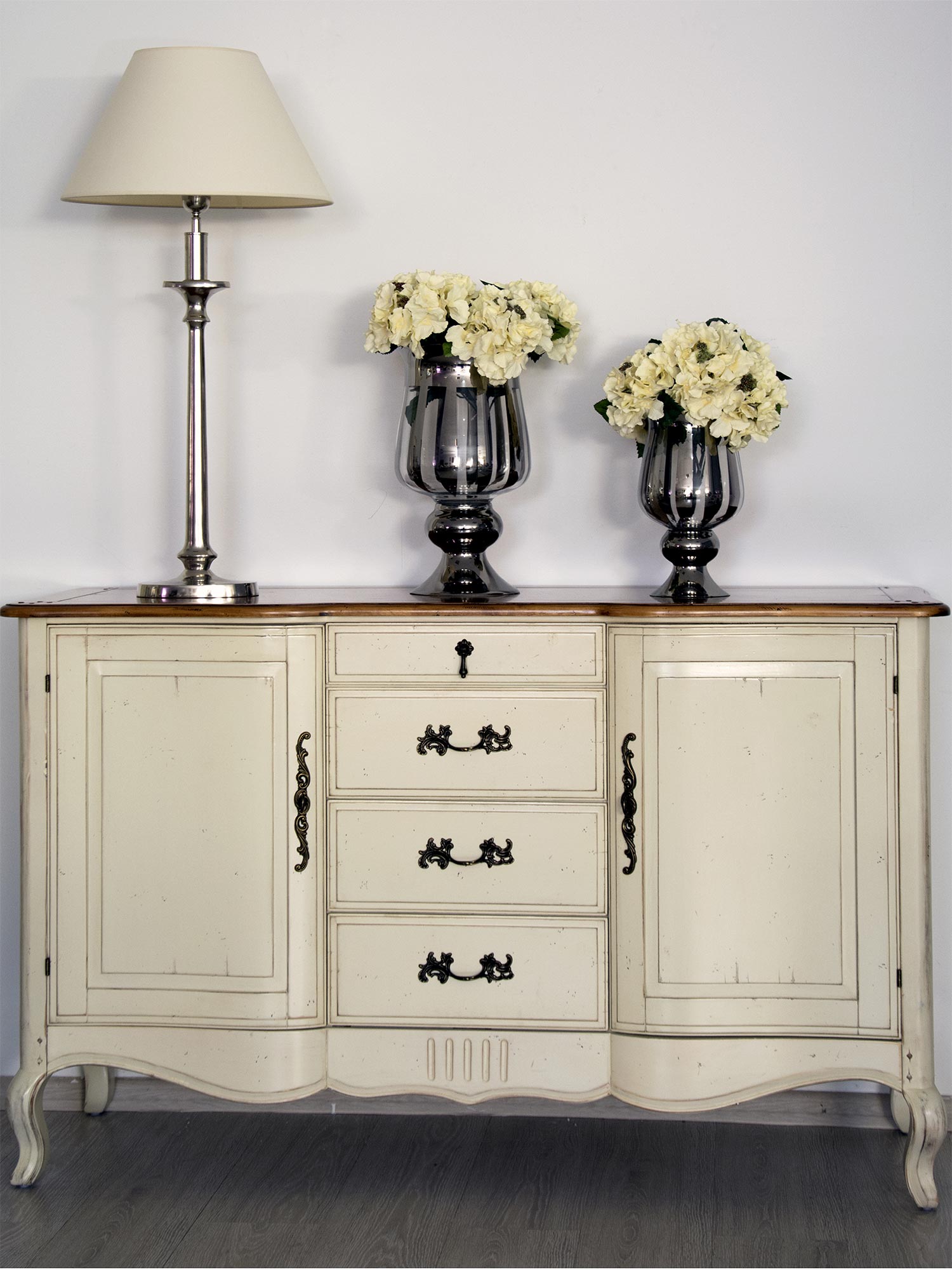 Drewniana komoda z dekoracyjnymi frontami i metalowymi uchwytami w stylu prowansalskim kolor biały