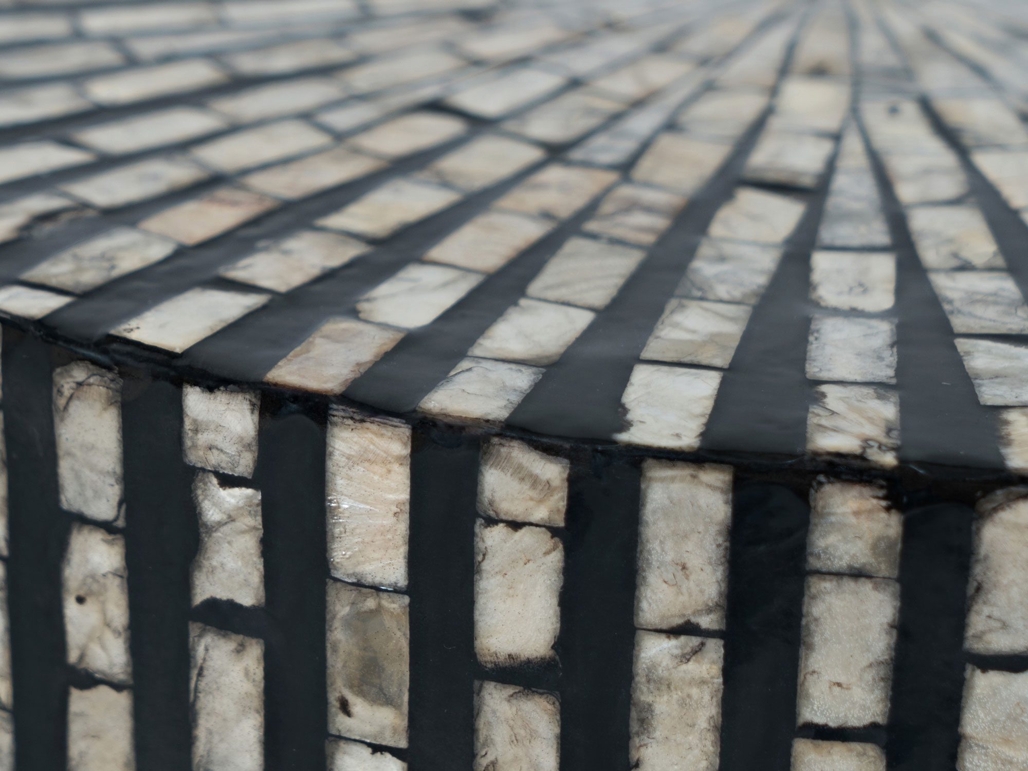 Szczegół wykończenia okrągłego stolika z geometrycznym wzorem kolor czarno-biały