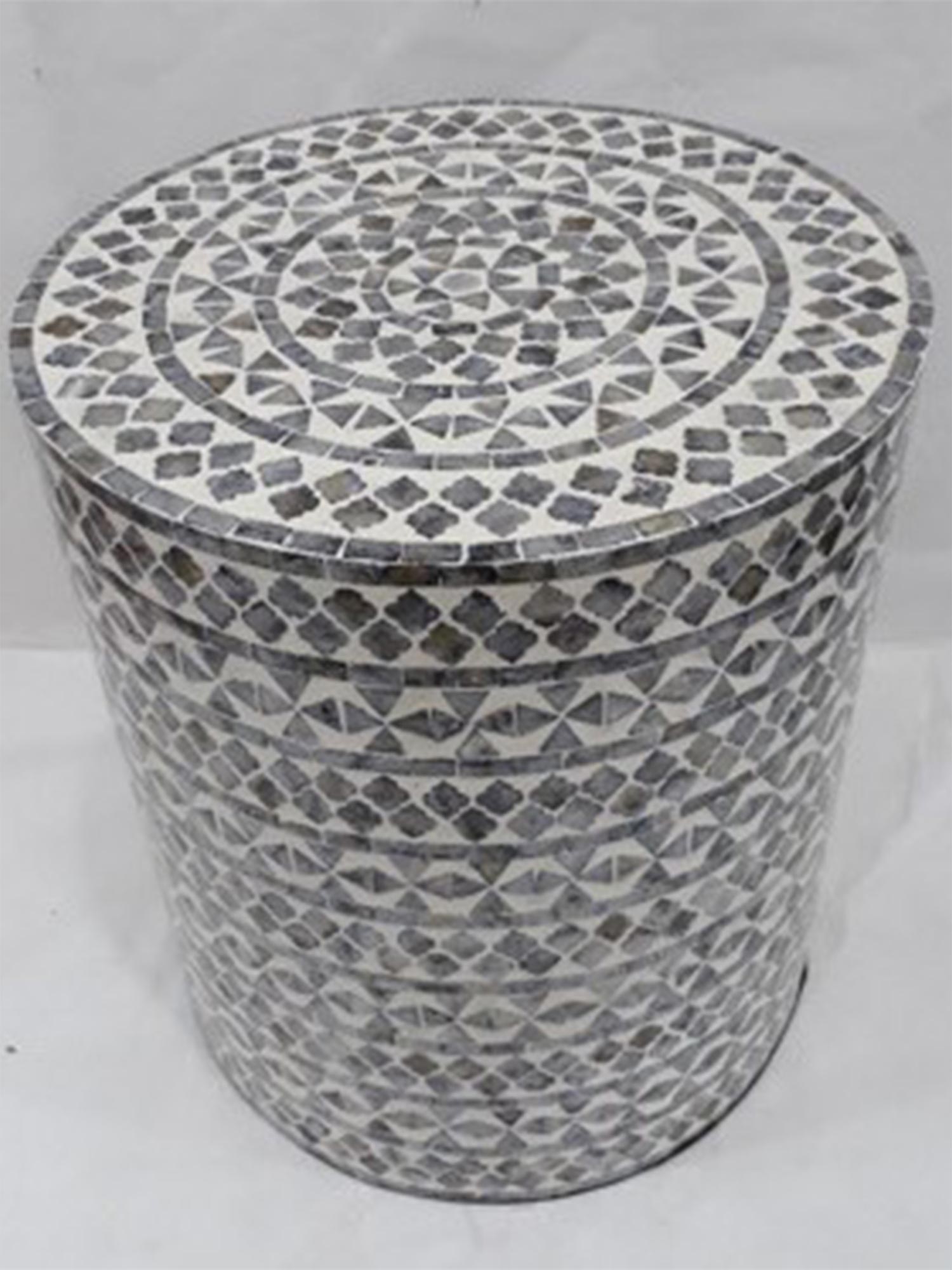 Detal plecionego wzoru kamienia na cylindrycznym stoliku bocznym