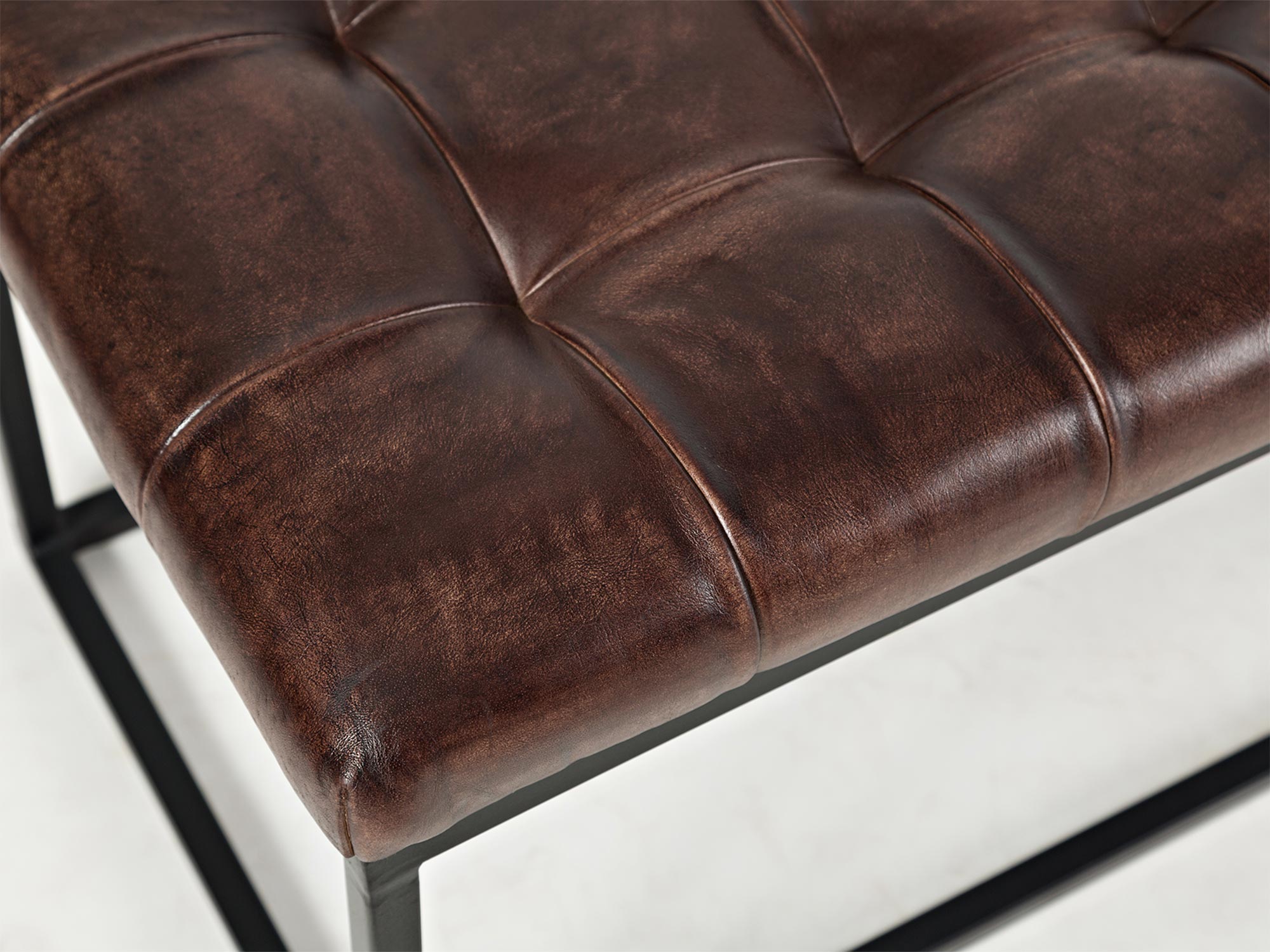 Detal tapicerowanego siedziska w stylu industrialnym z metalową ramą Detal tapicerowanego siedziska w stylu industrialnym z metalową ramą